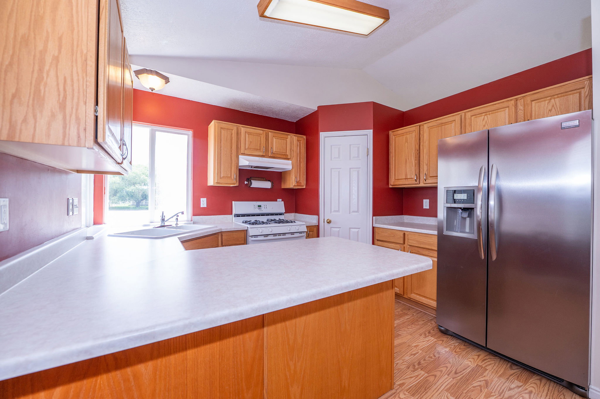 Kitchen featuring wood-finish flooring and red walls