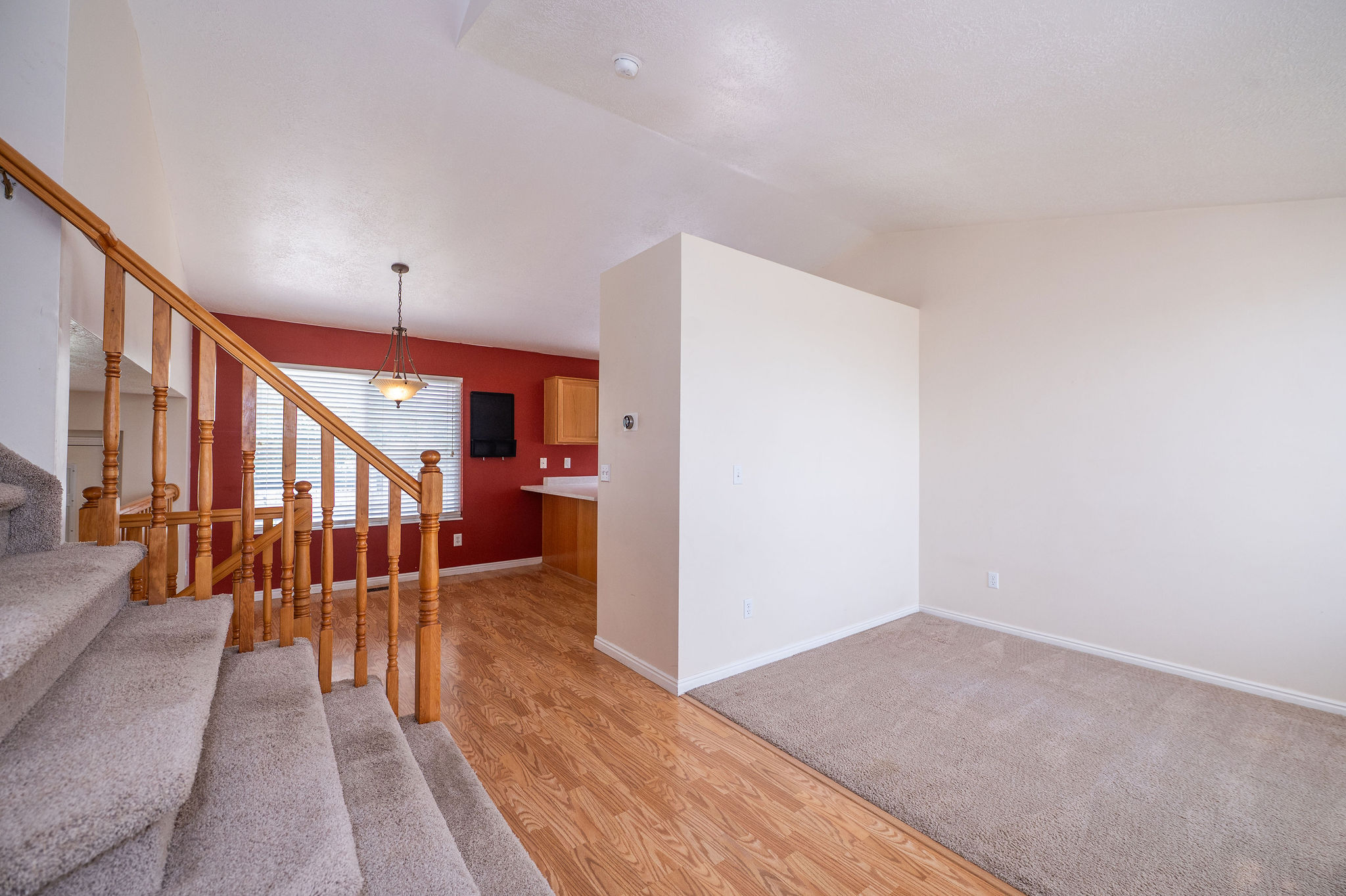 Carpeted staircase with wood railing and balusters