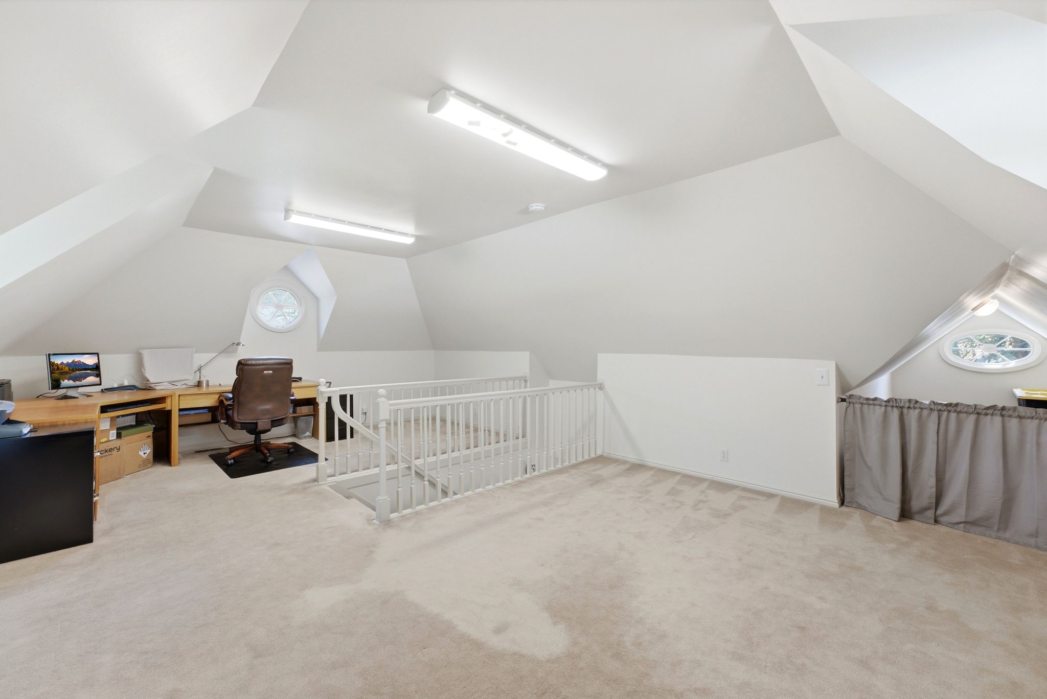 Carpeted loft space featuring sloped ceilings and white walls