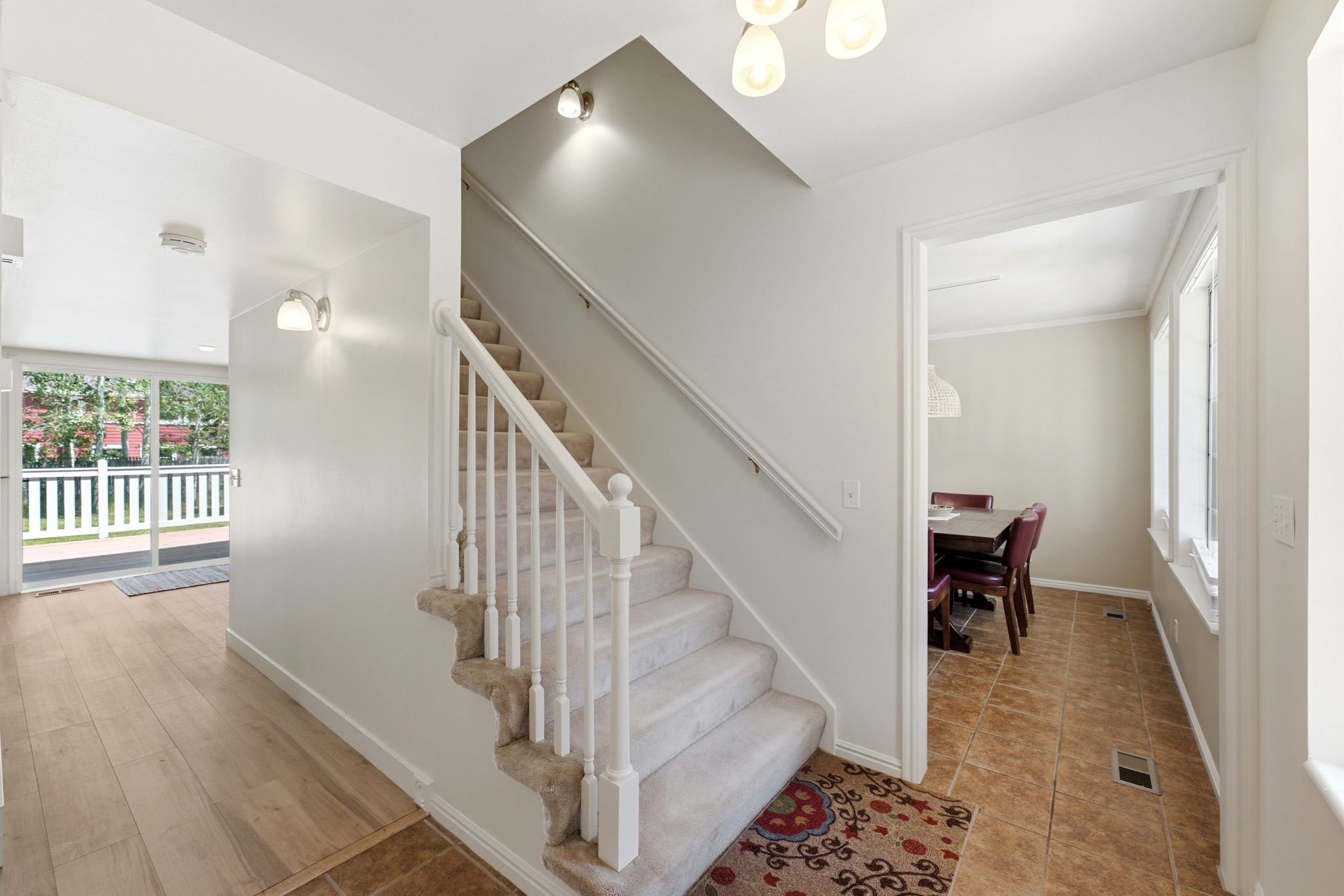 Carpeted staircase with white balusters and handrail