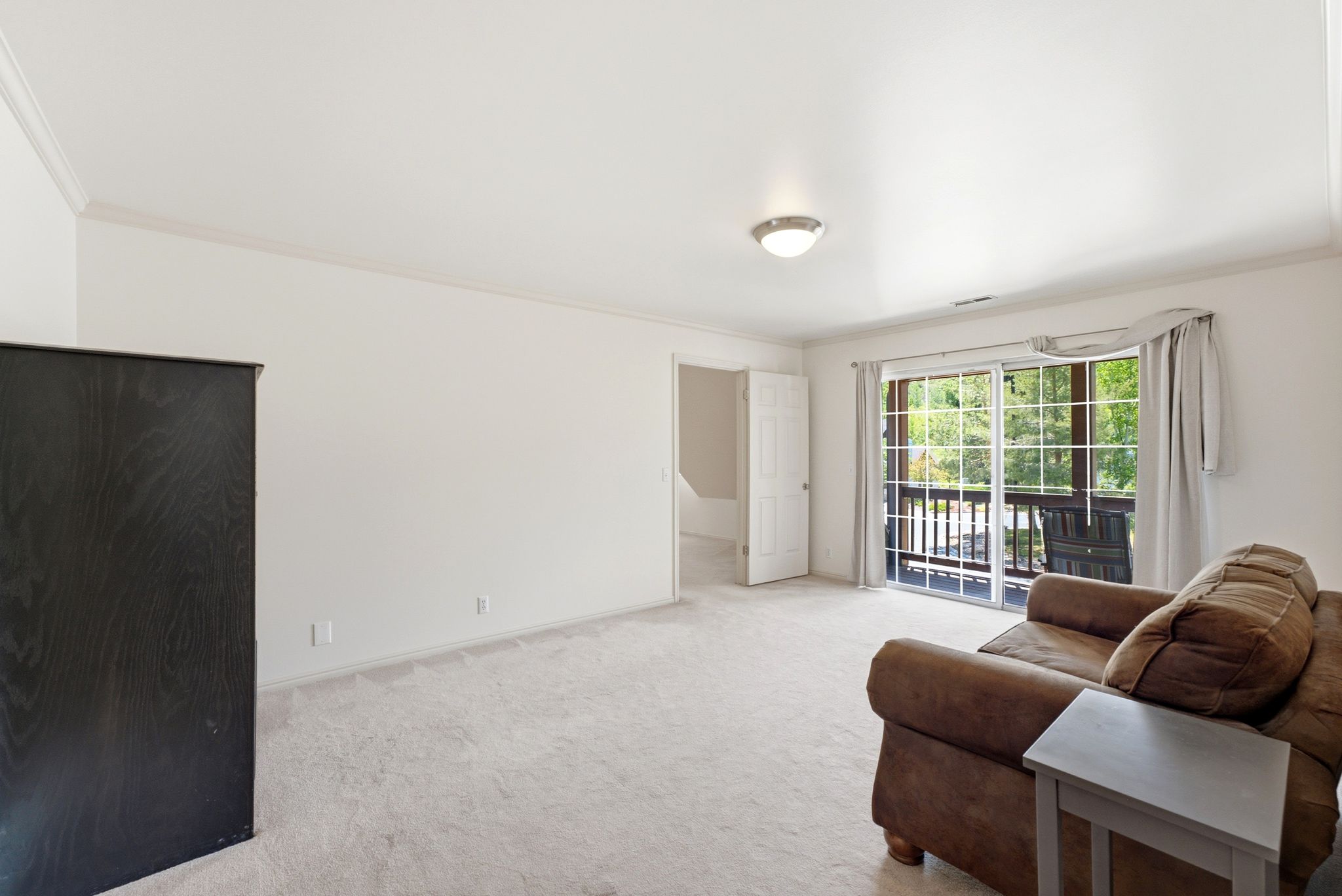 Carpeted room with white walls and crown molding