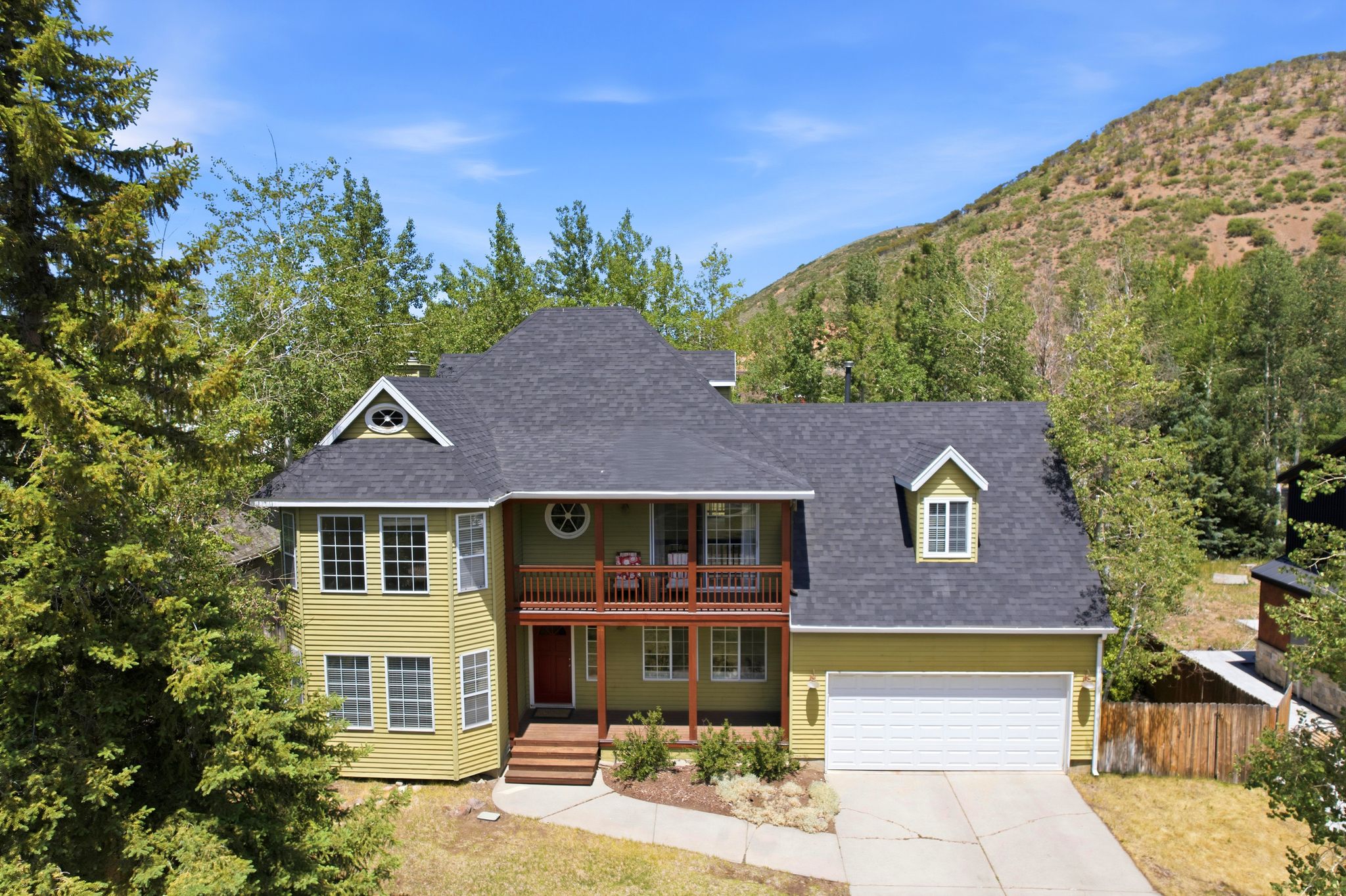 Traditional-style residence featuring light green siding and a dark shingle roof