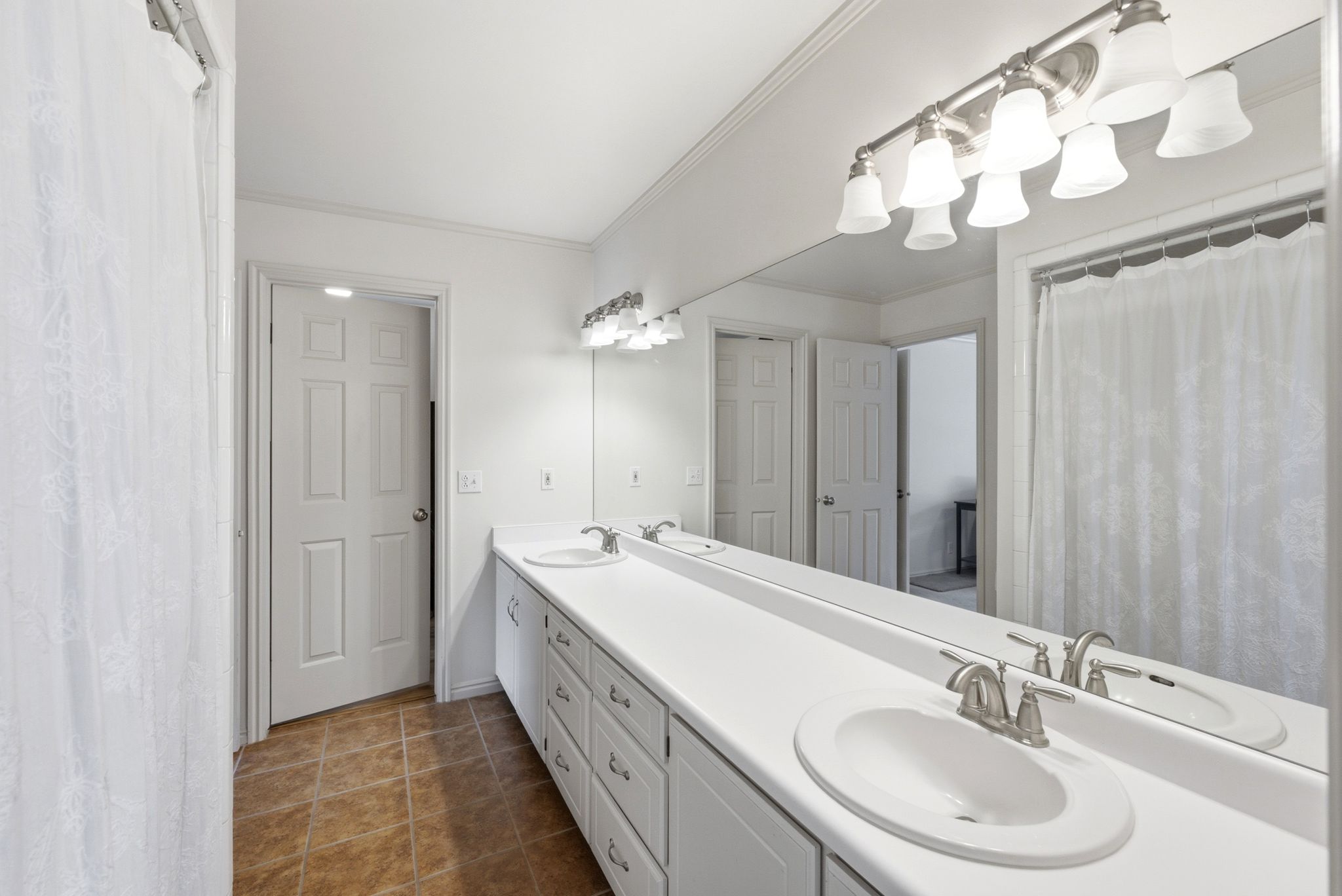 Bathroom featuring a dual vanity with white countertops and integrated sinks