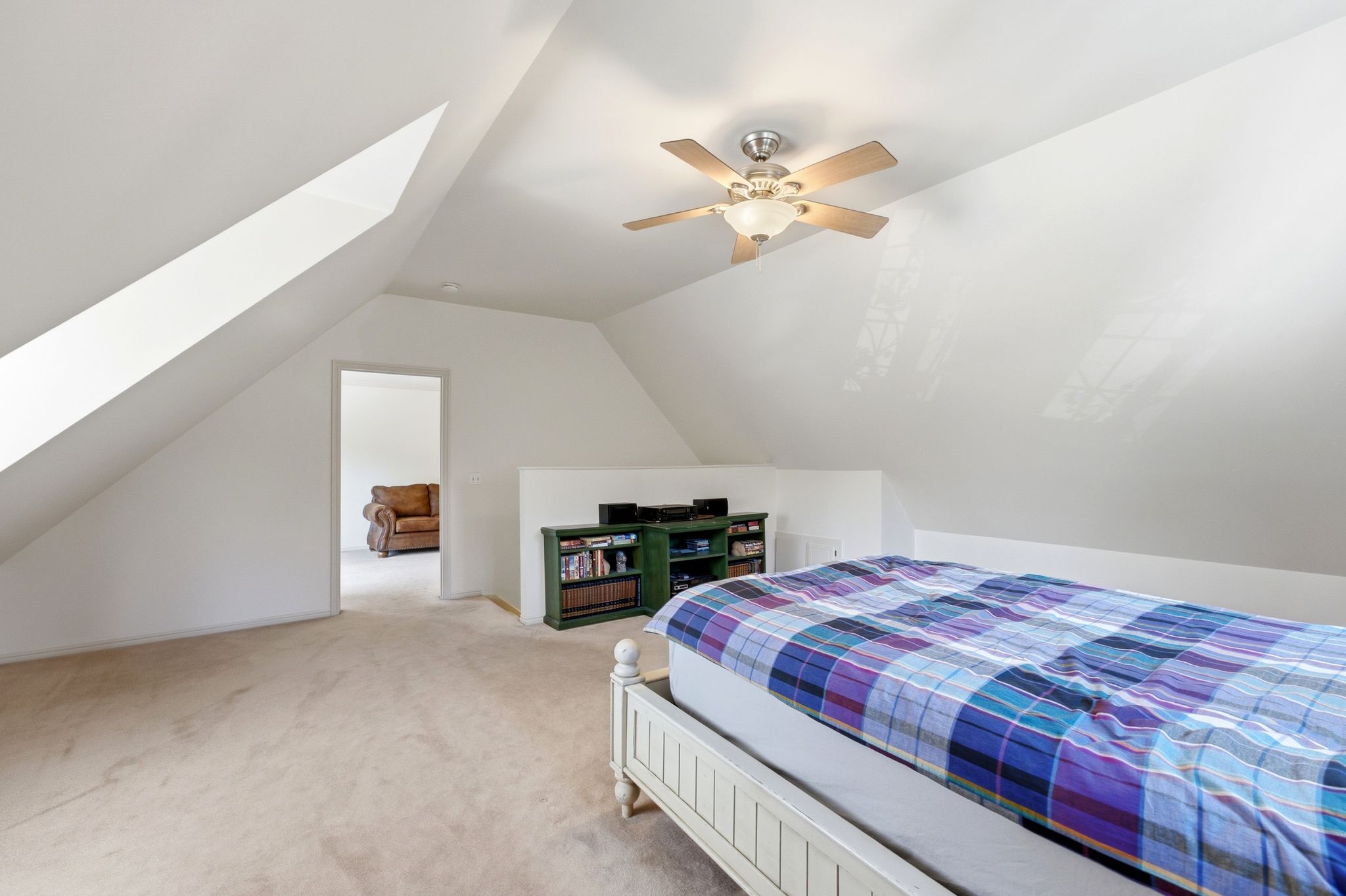 Carpeted room with sloped ceilings and white walls