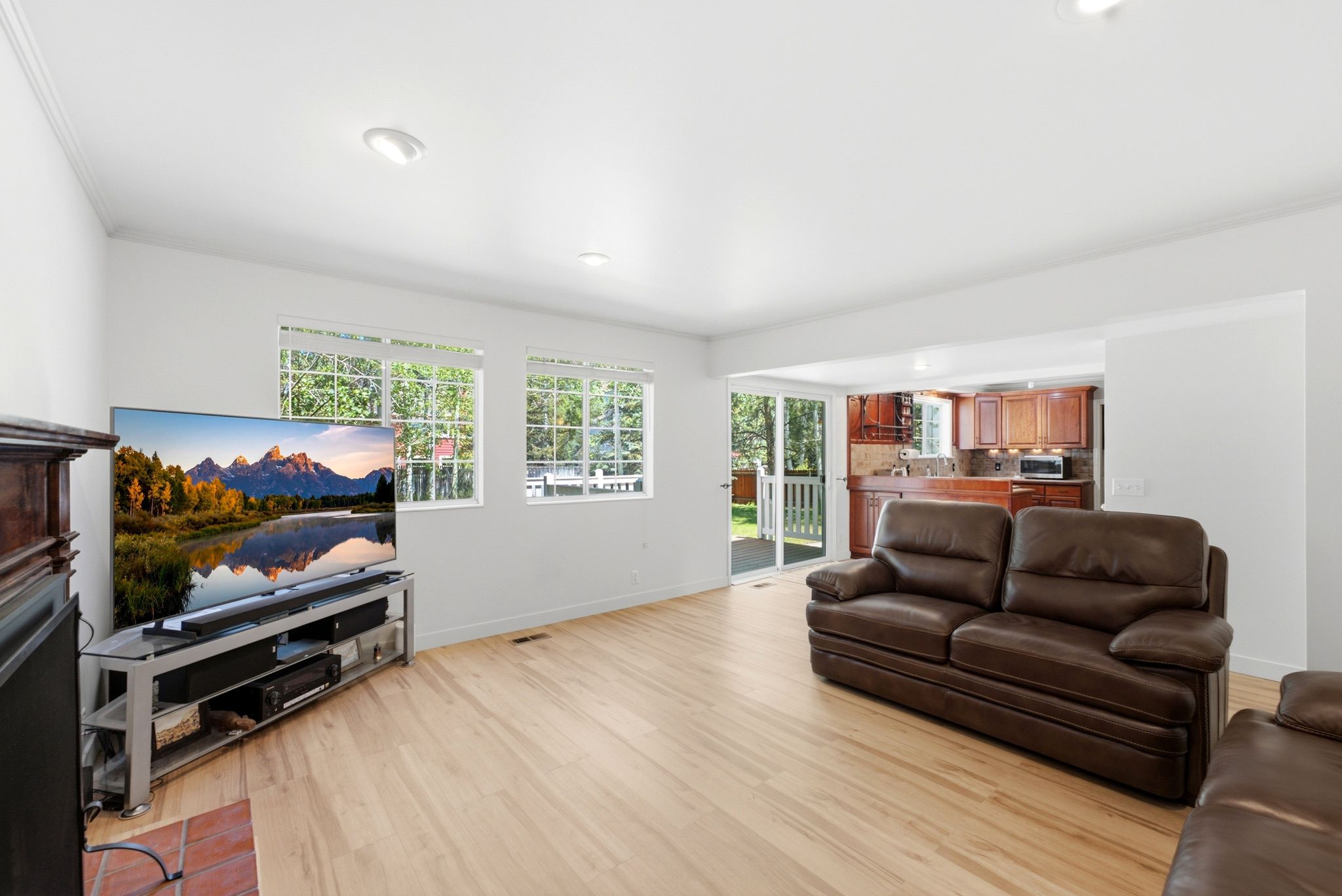 Bright living area featuring wood-finish flooring, recessed lighting, and white trim