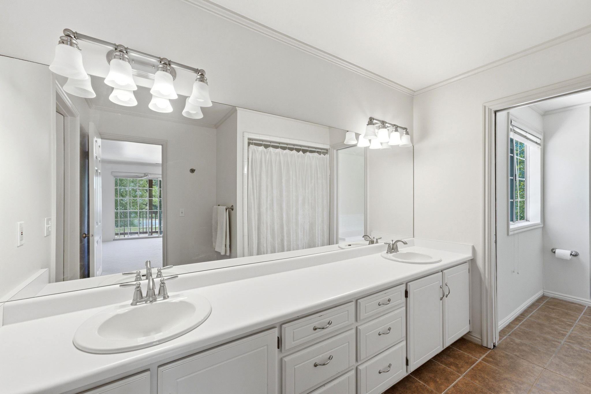 Bathroom featuring a dual vanity with white countertops, under-mount sinks, and brushed nickel faucets