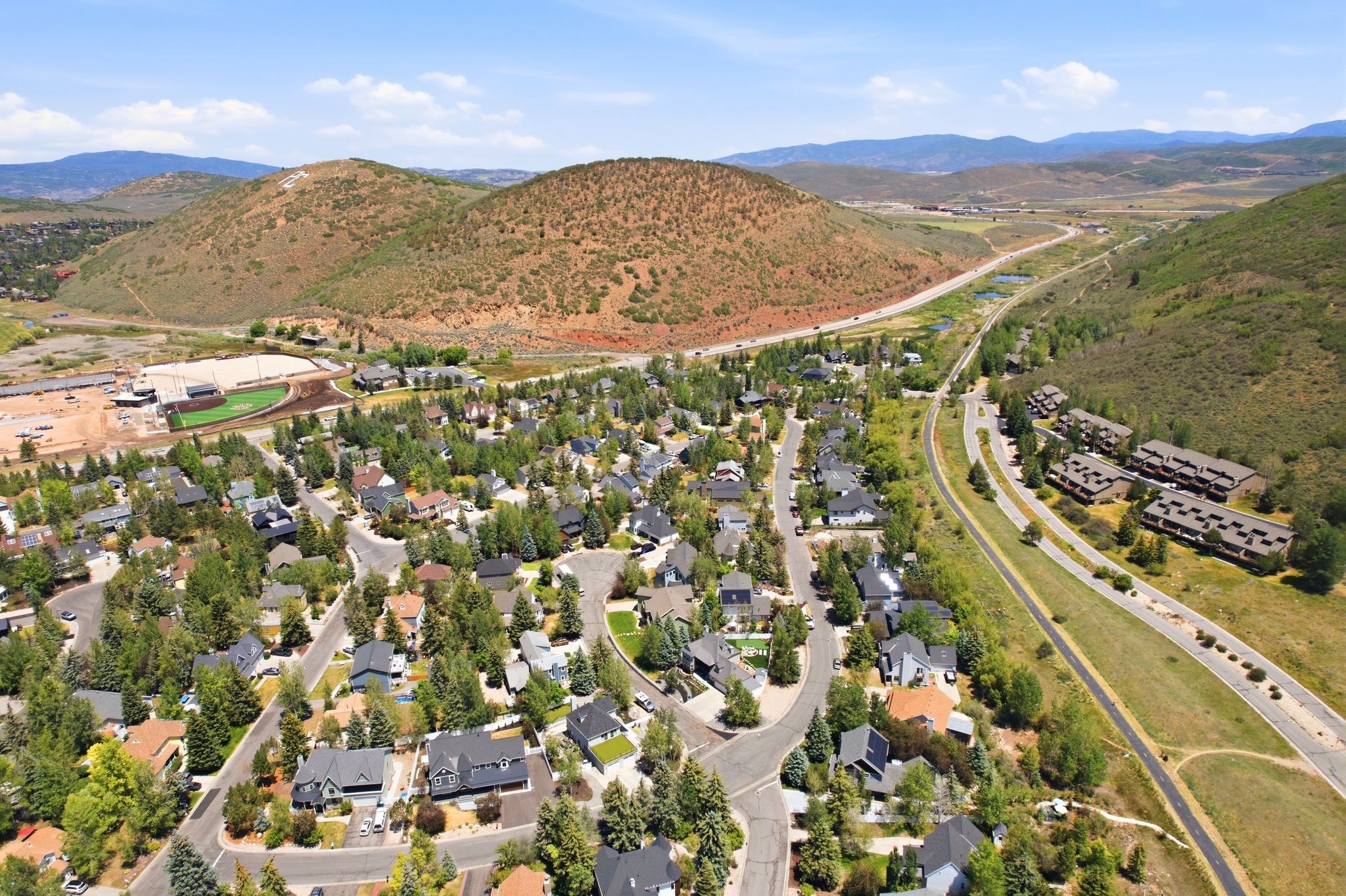 Aerial perspective of a developed residential area featuring numerous single-family homes and multi-unit buildings