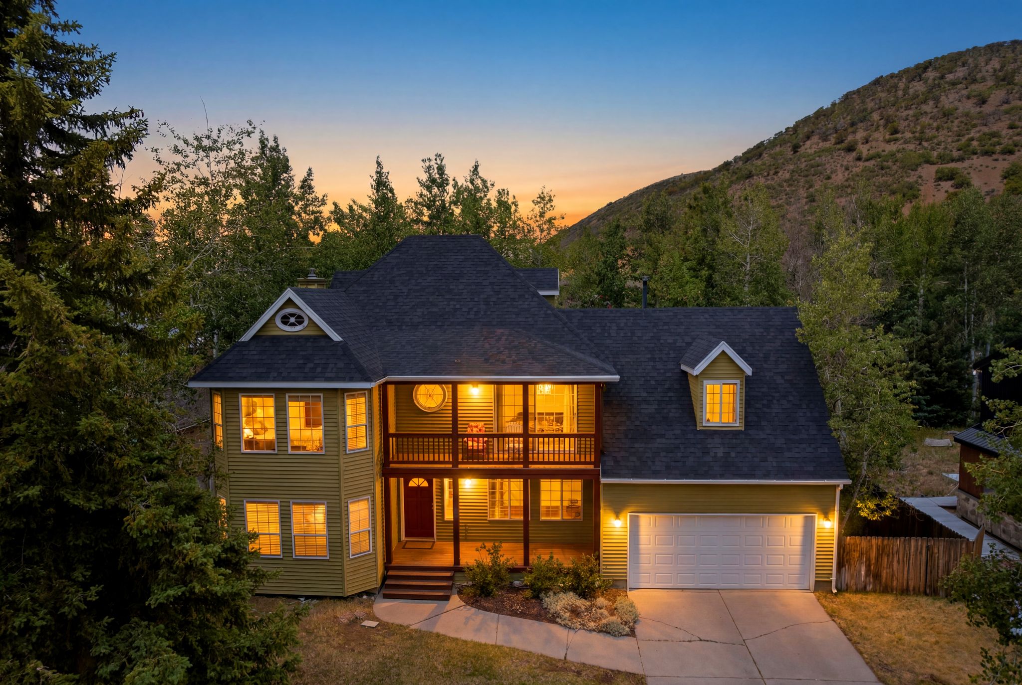 Exterior featuring a covered porch, upper-level balcony, dormer windows, and attached garage