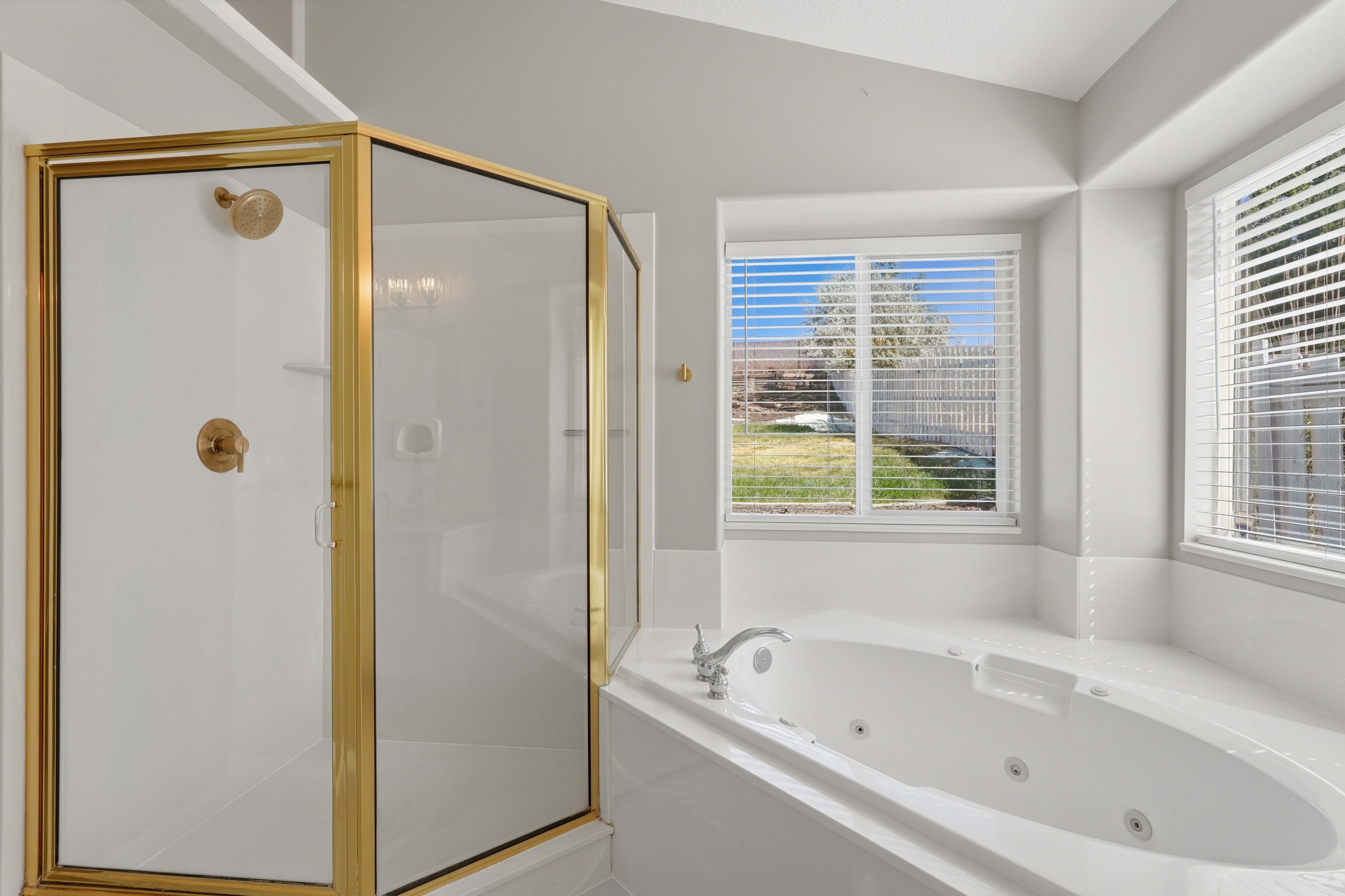 Corner shower enclosure with brass-finish framing and hardware