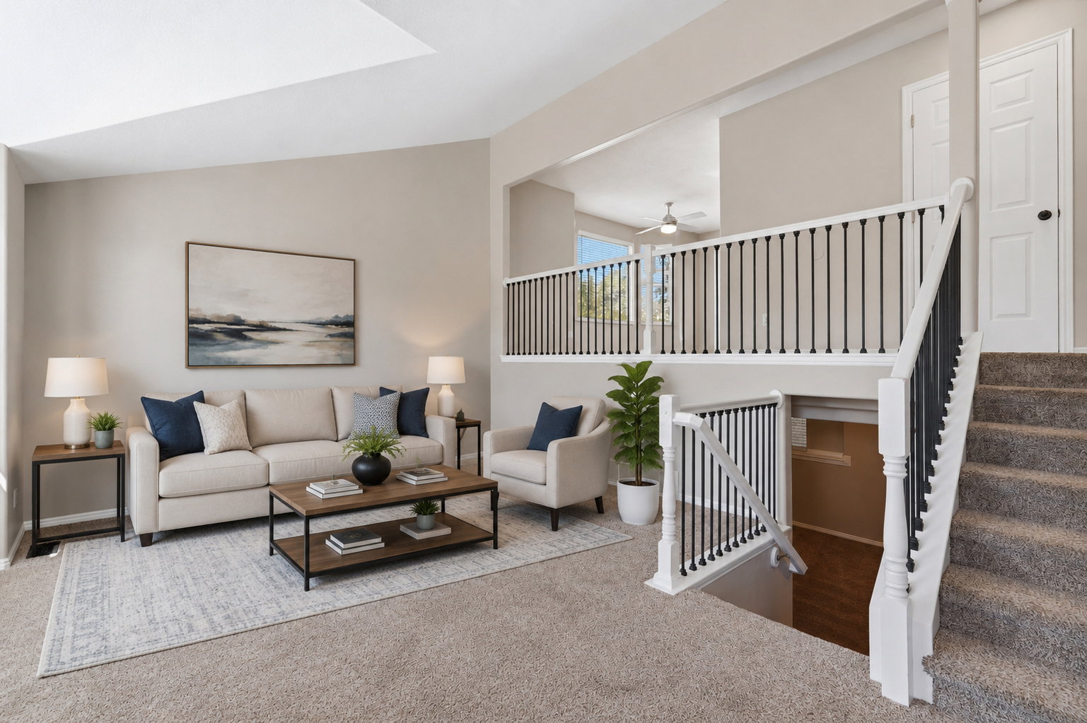 Open-concept living space featuring a carpeted main level, high ceilings, and a neutral color palette. Staged virtually.