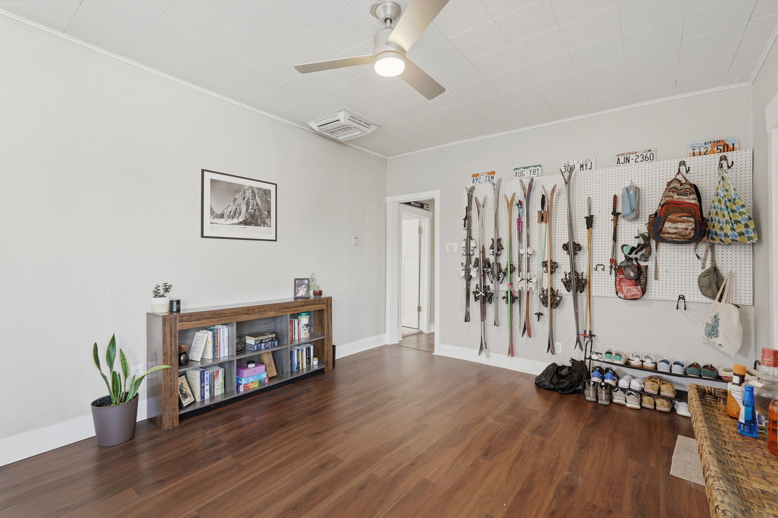 Spacious room with wood-finish flooring, light grey walls, and a recessed panel ceiling