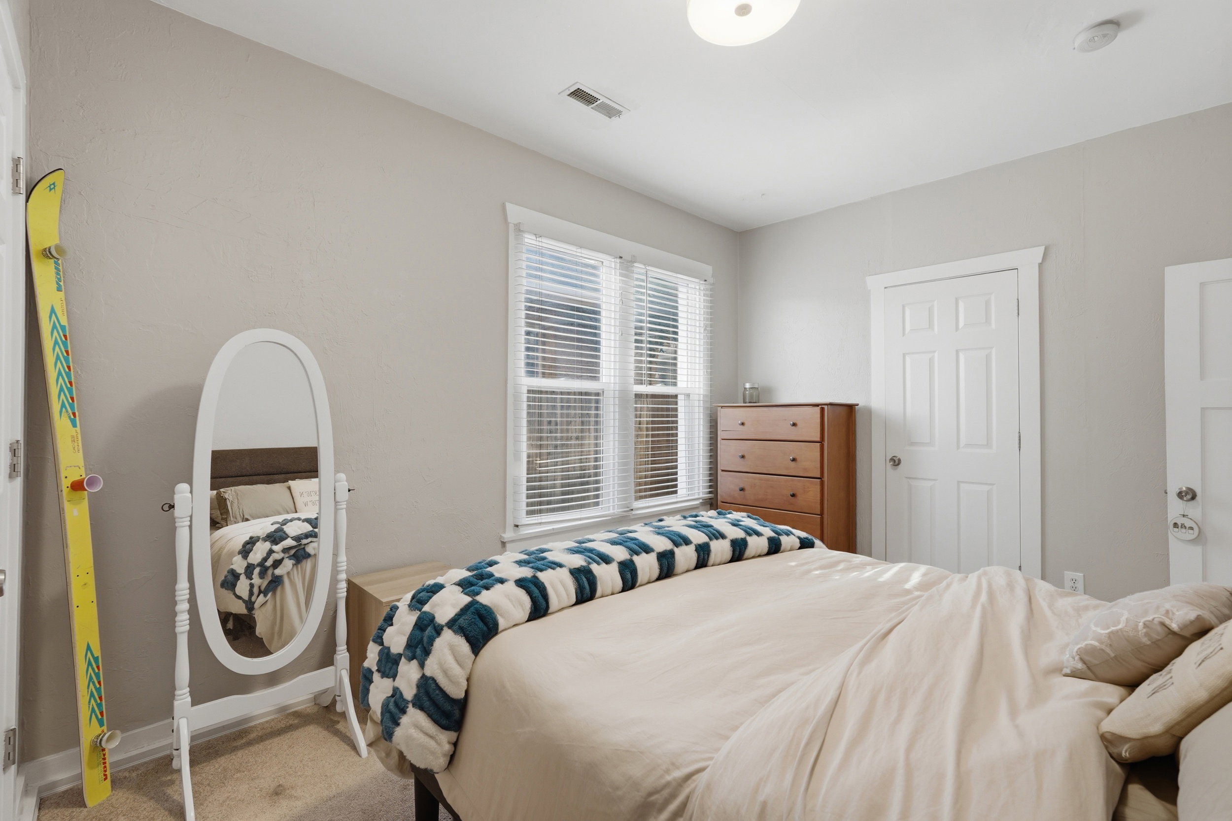 Bedroom featuring light neutral walls, a window with blinds, and white trim