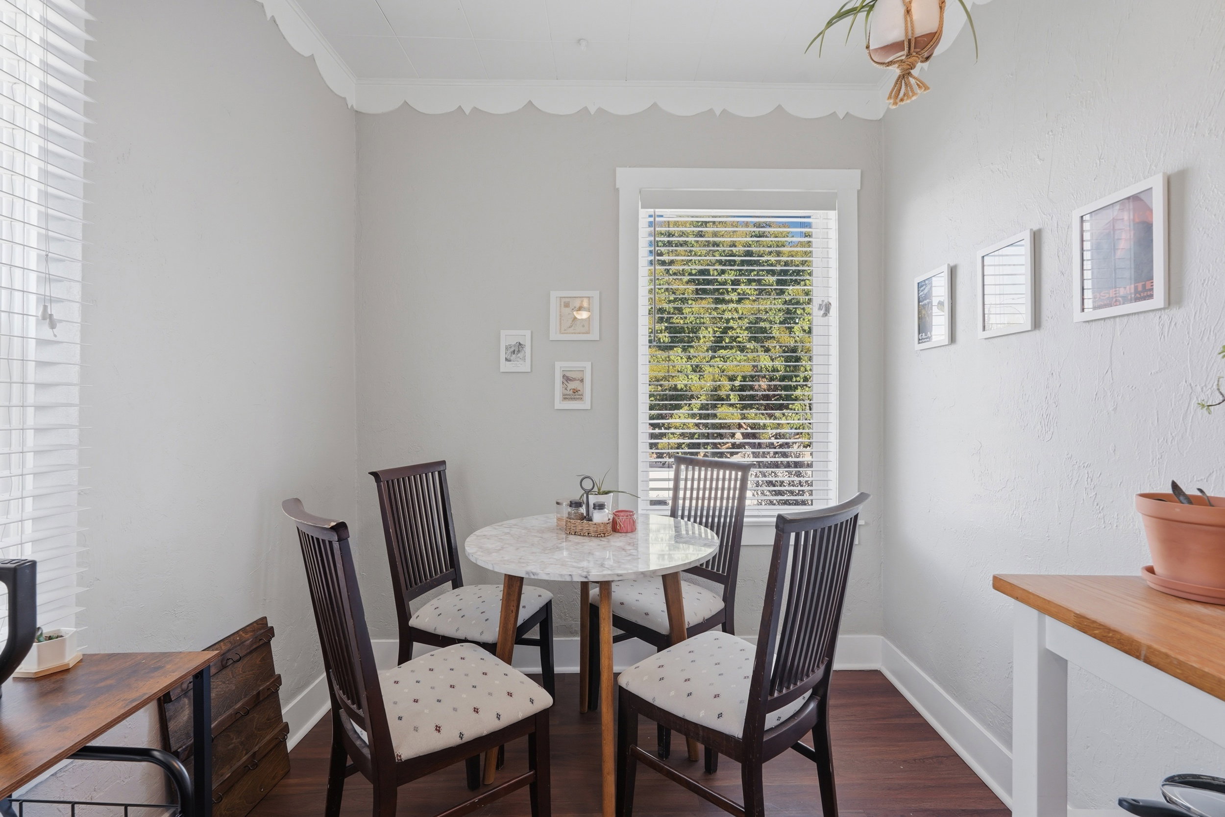 Bright dining nook featuring dark wood-finish flooring, white trim, and a window with natural light