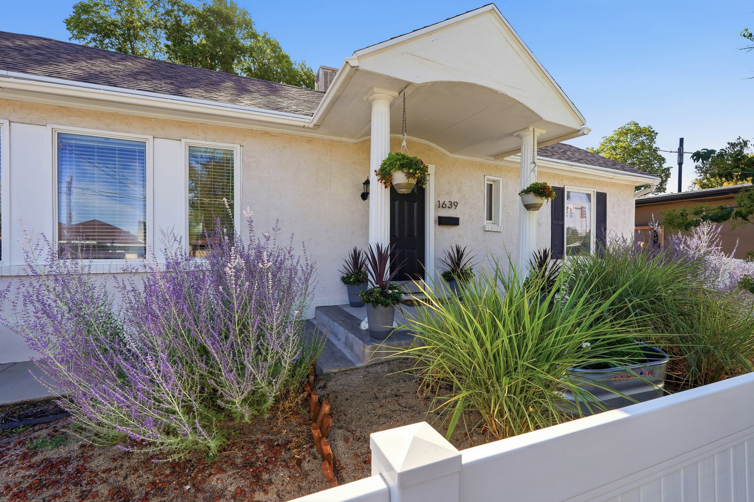 Charming stucco exterior featuring a covered porch entry with white columns