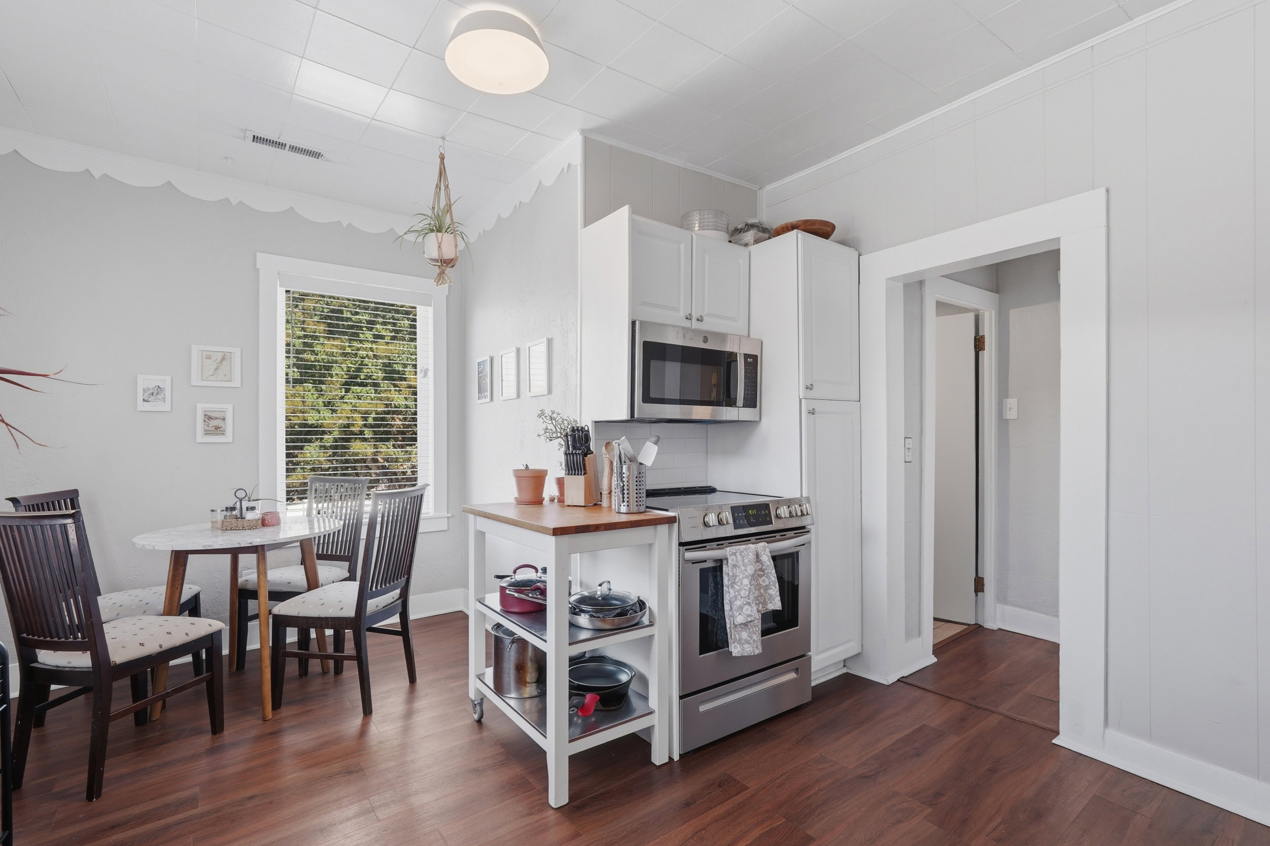 Kitchen area featuring wood-finish flooring and white cabinetry