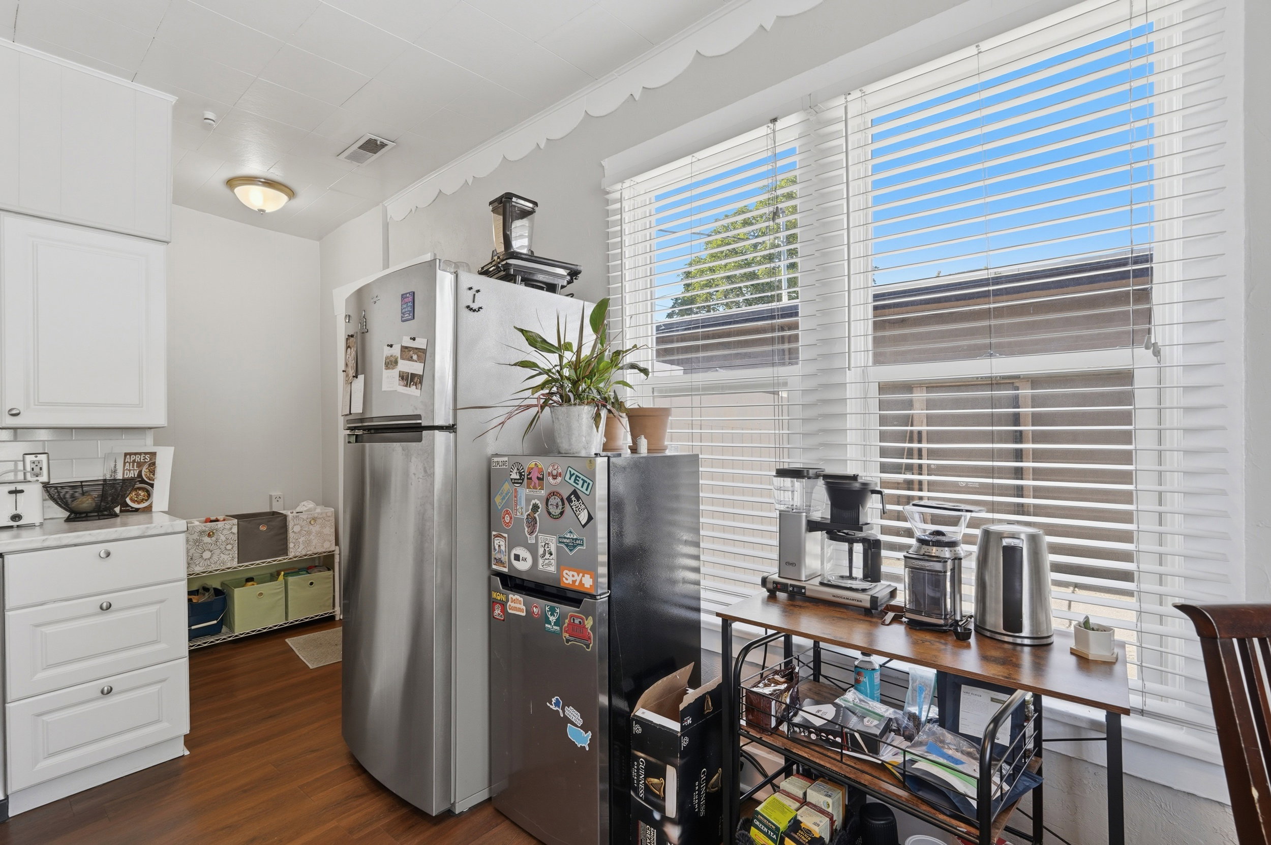 Kitchen featuring wood-finish flooring, white cabinetry, and a white subway tile backsplash
