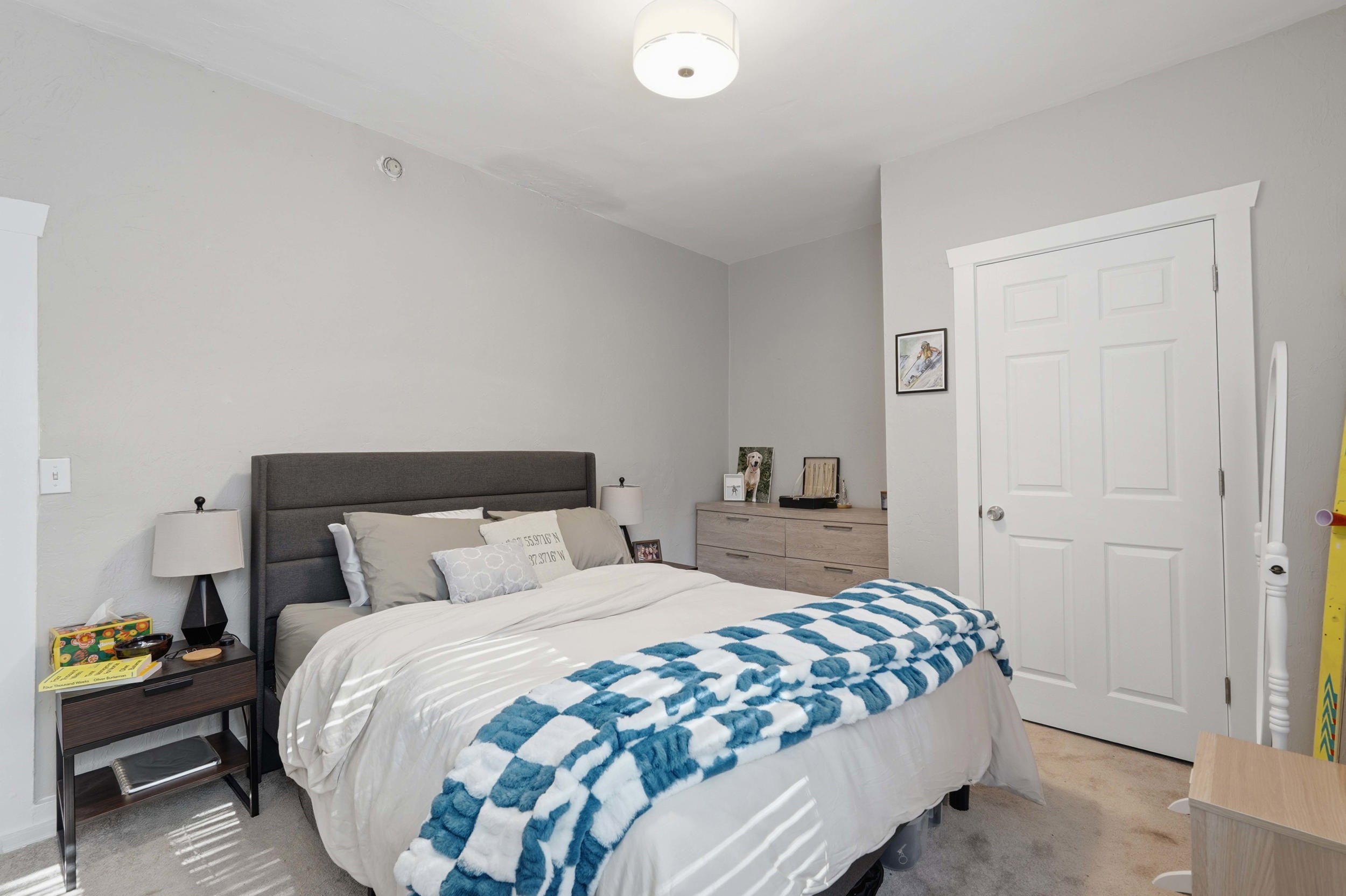 Bedroom featuring light gray walls, white trim, and a four-panel interior door
