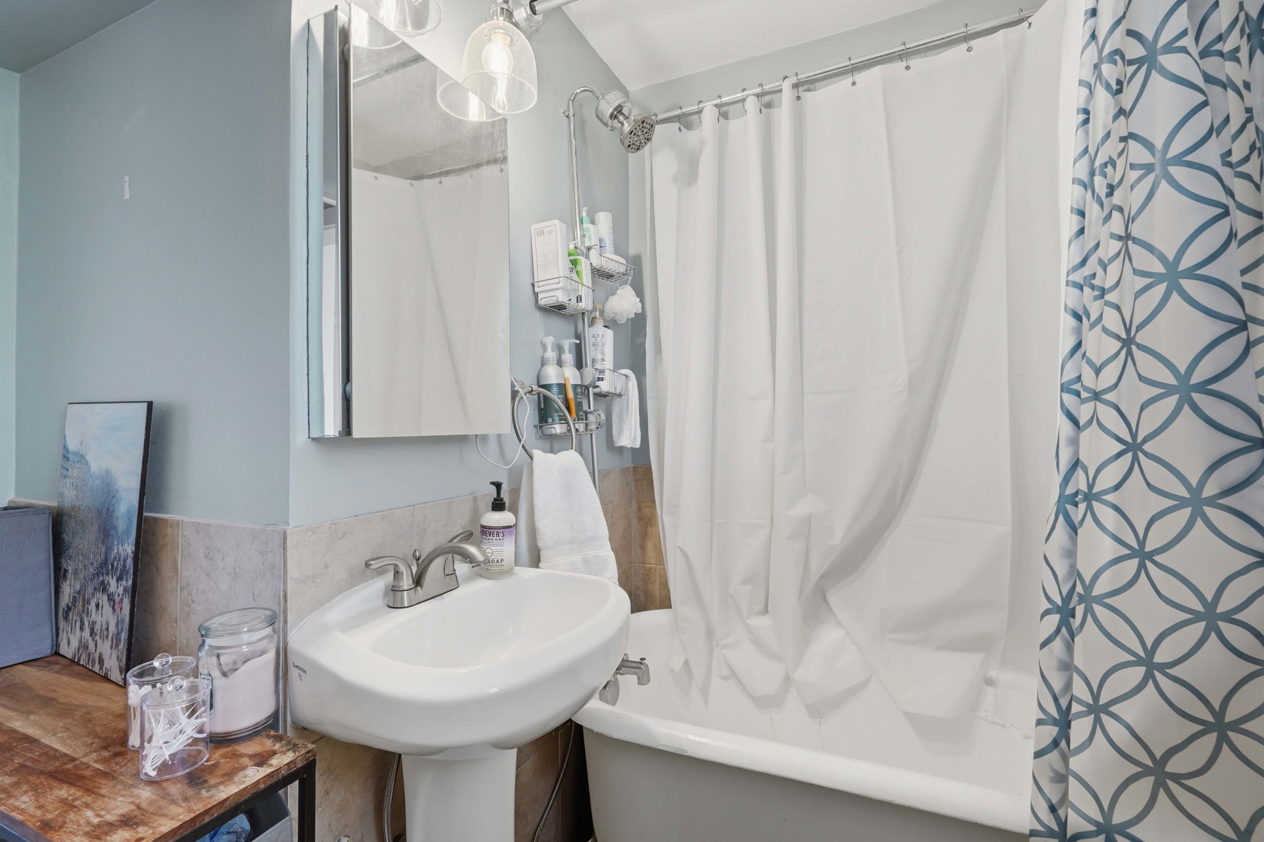 Pedestal sink with chrome faucet, medicine cabinet, and overhead light fixture