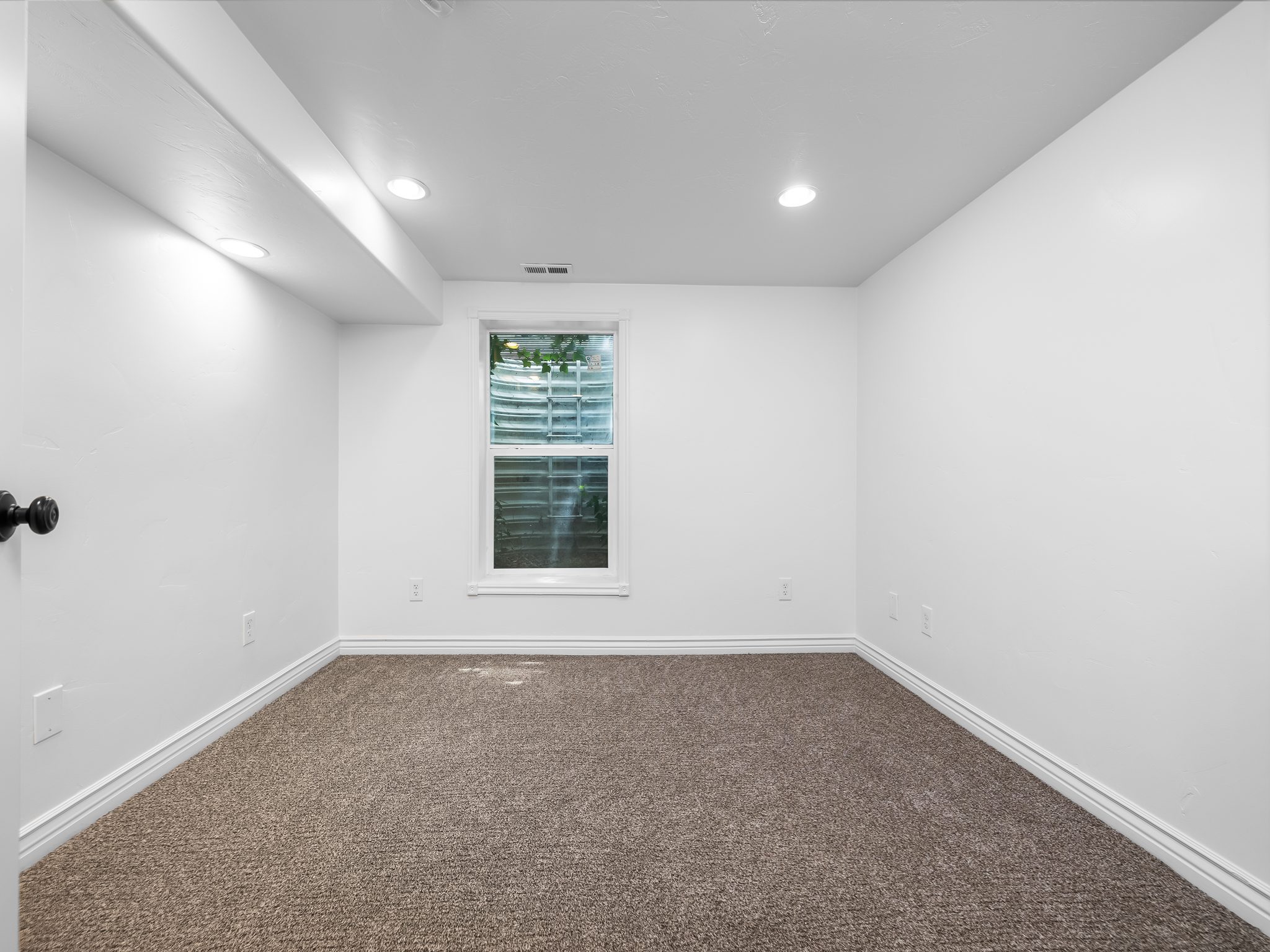 Carpeted interior space featuring a window, recessed lighting, white walls, and white baseboards