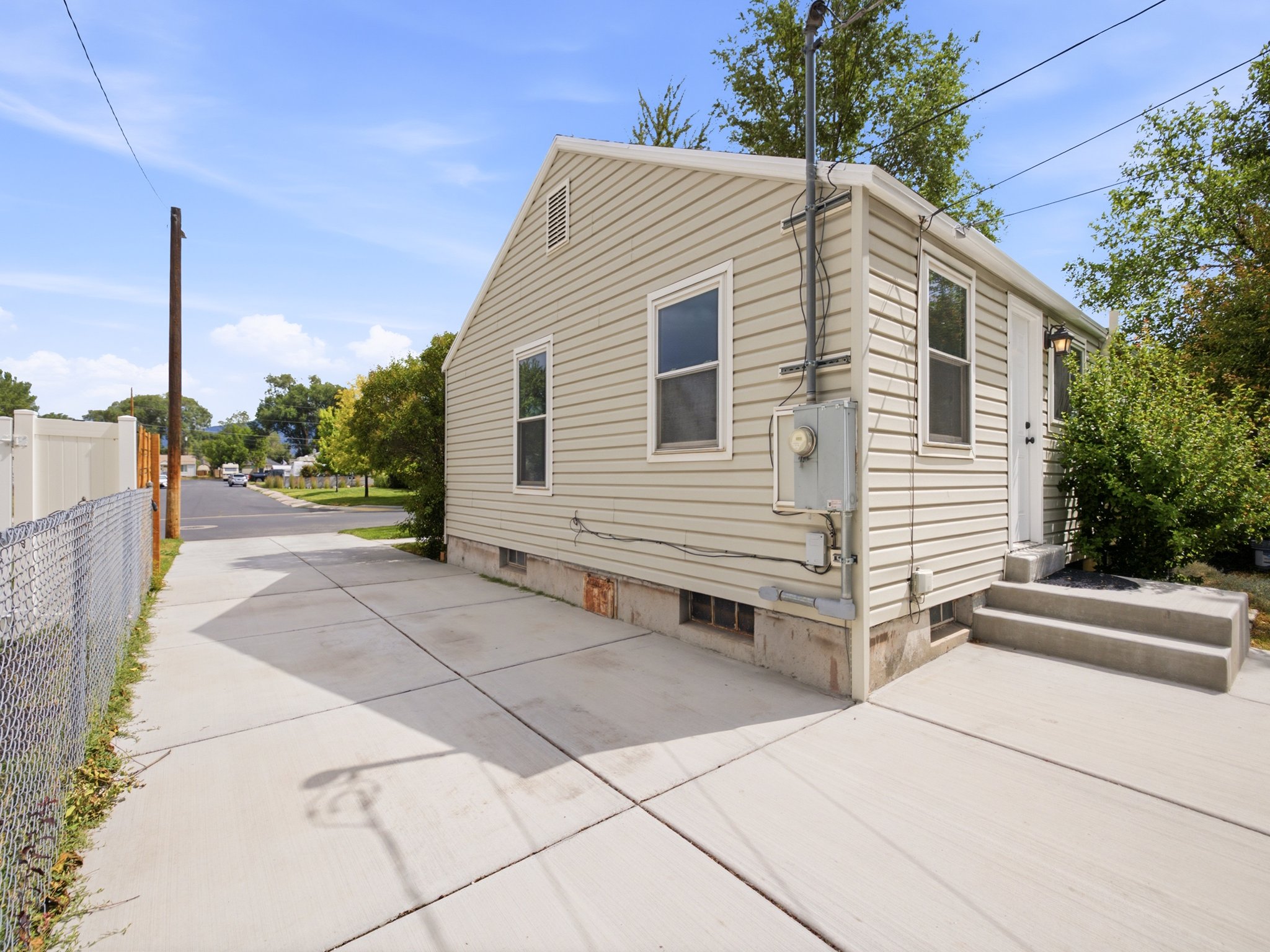 Hardie board siding exterior with concrete steps and a side entrance