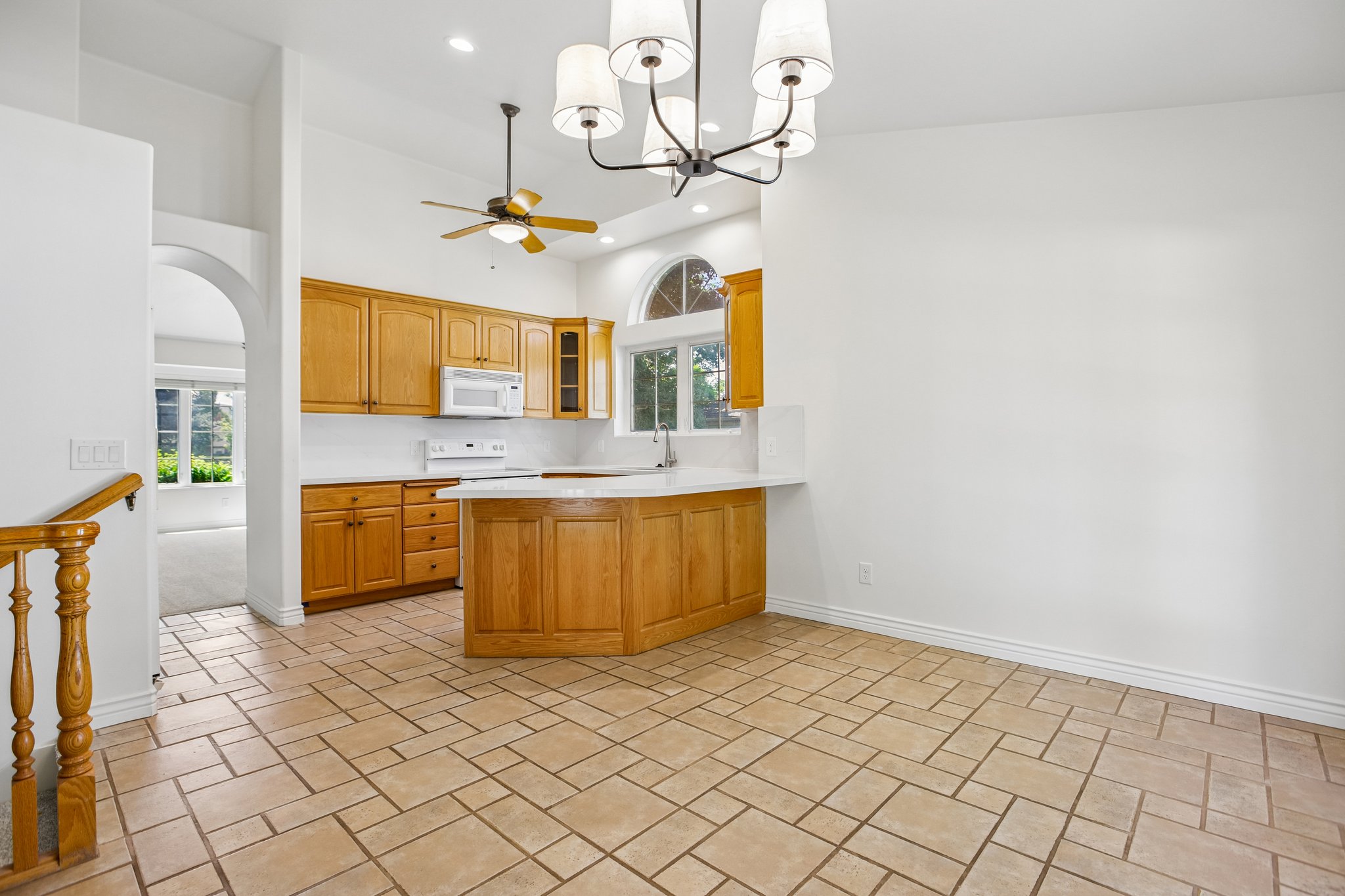 Kitchen with wood cabinetry, white countertops, and a built-in breakfast bar