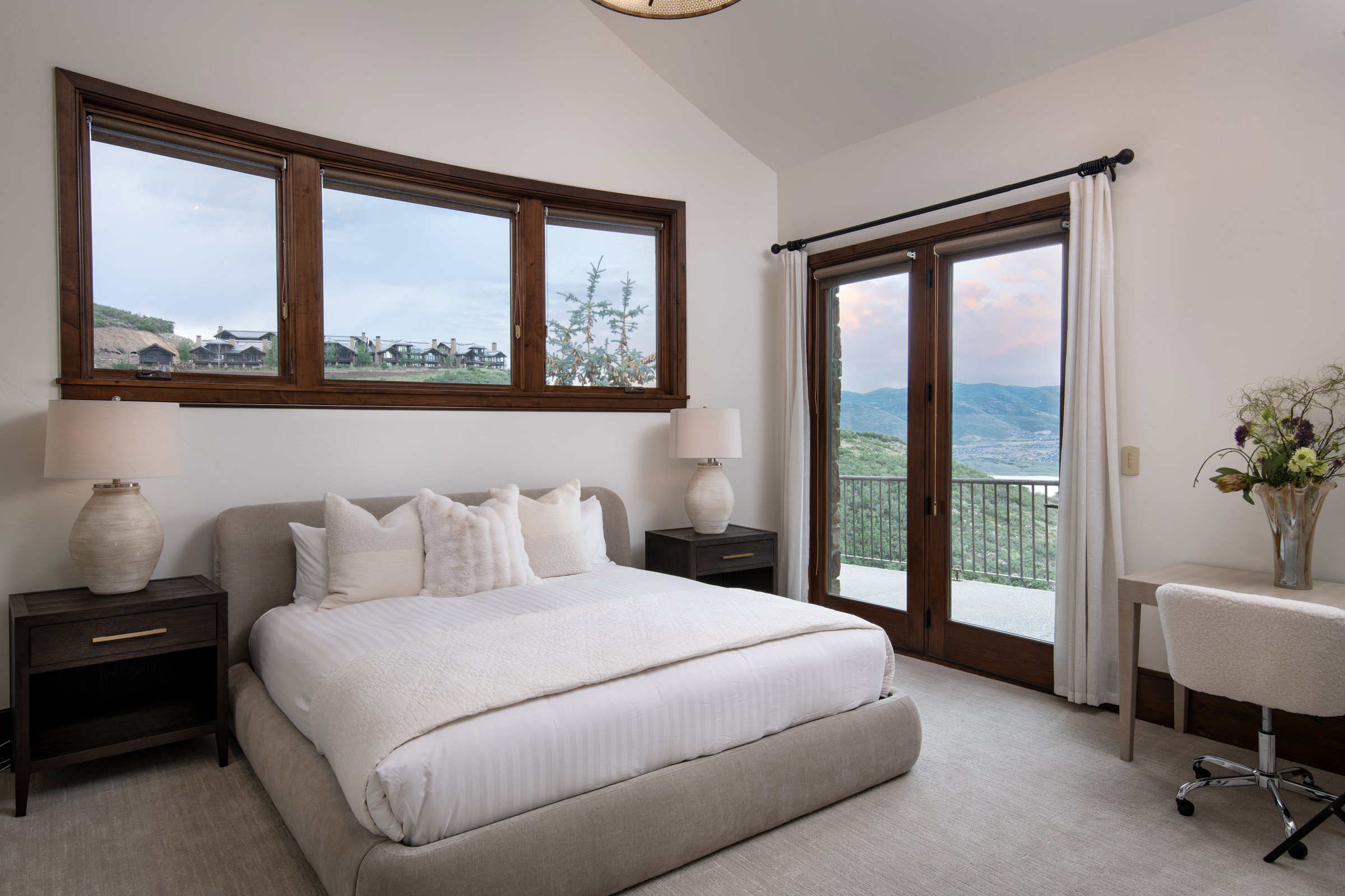 Vaulted ceiling room featuring light-toned carpeting and white walls
