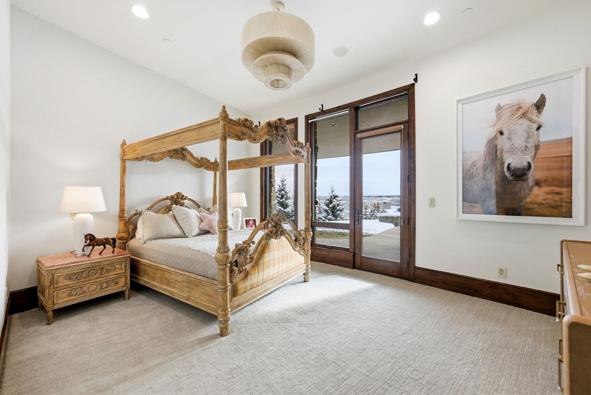 Recessed lighting illuminates a spacious room featuring light-toned carpeting and white walls