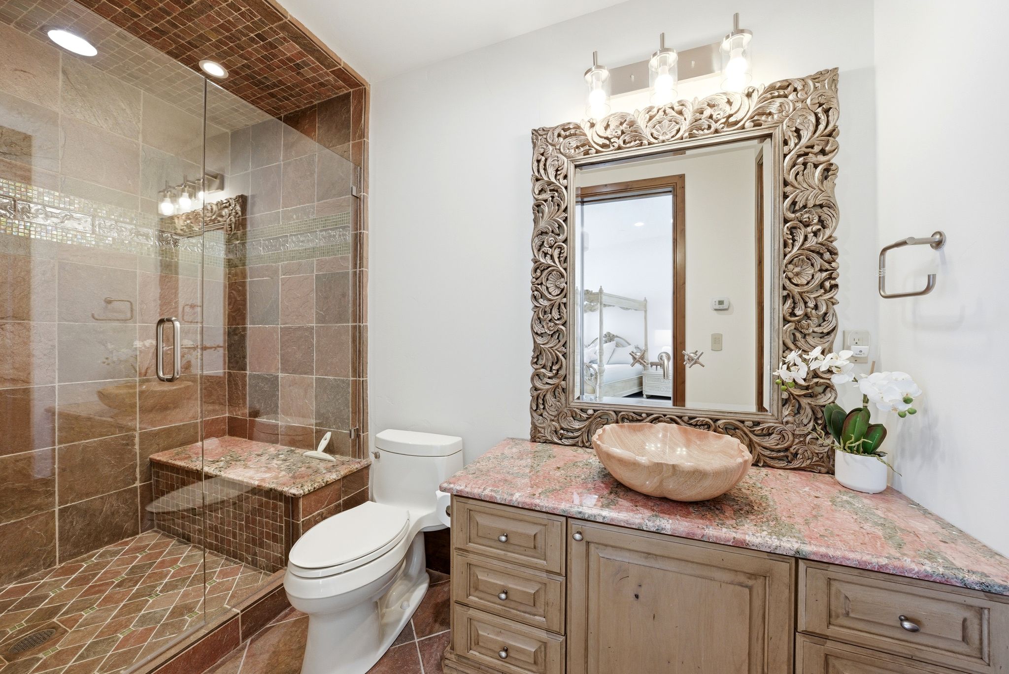 Bathroom featuring a glass-enclosed shower with tiled walls and a built-in bench