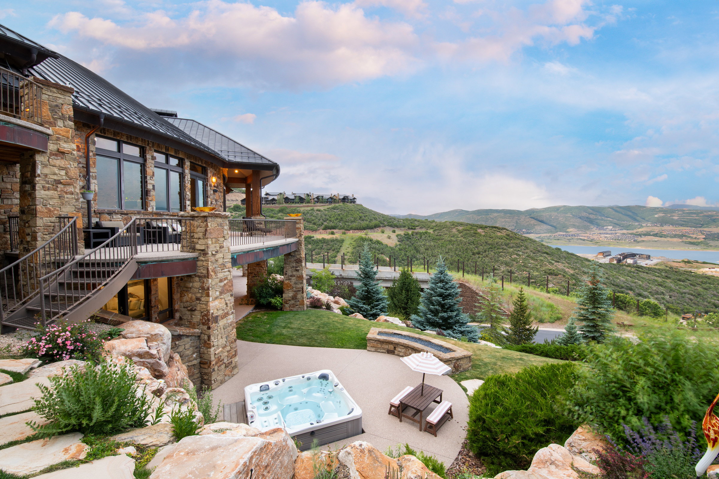 Stone exterior residence with multiple outdoor living areas