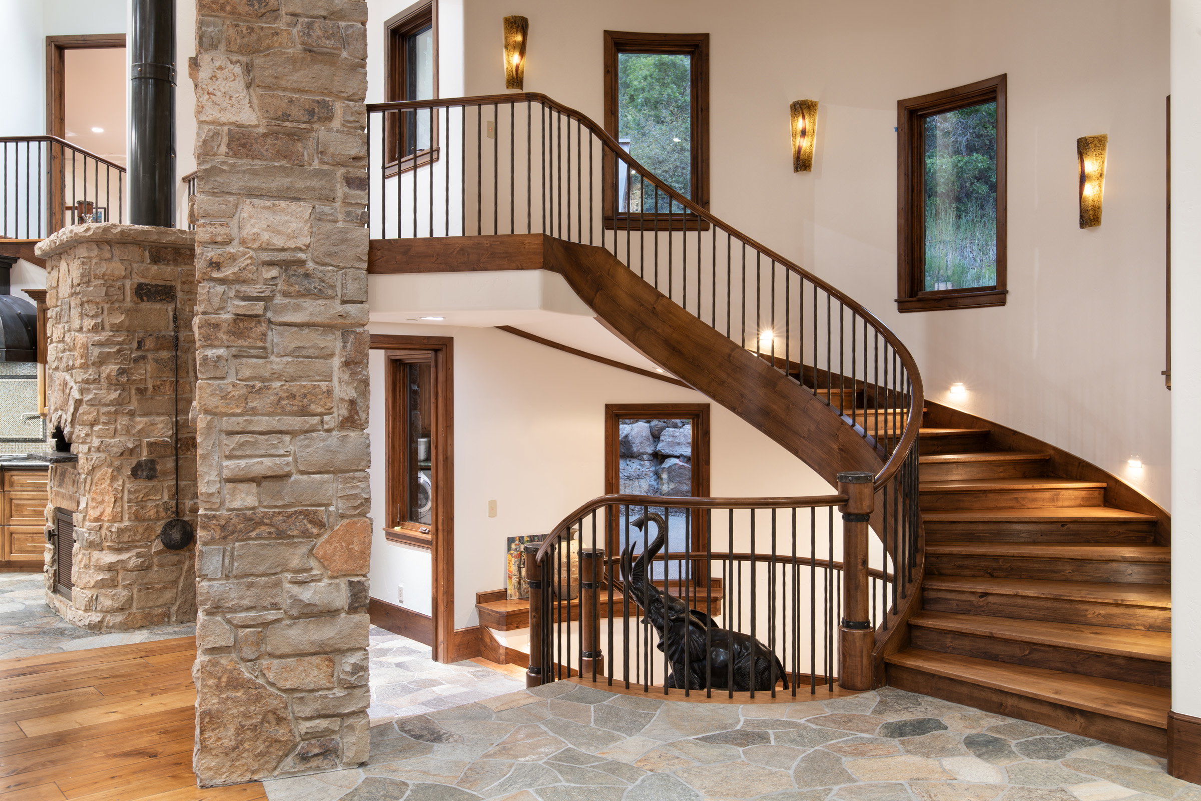 Curved staircase with wood-finish treads and wrought iron balusters