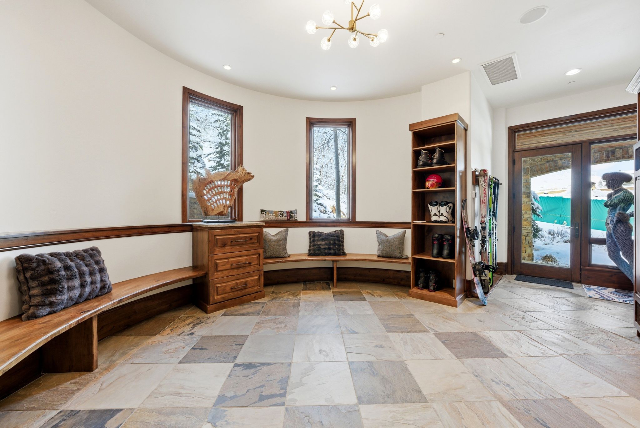 Curved entryway featuring extensive multi-tone tile flooring, built-in wooden benches, and custom cabinetry