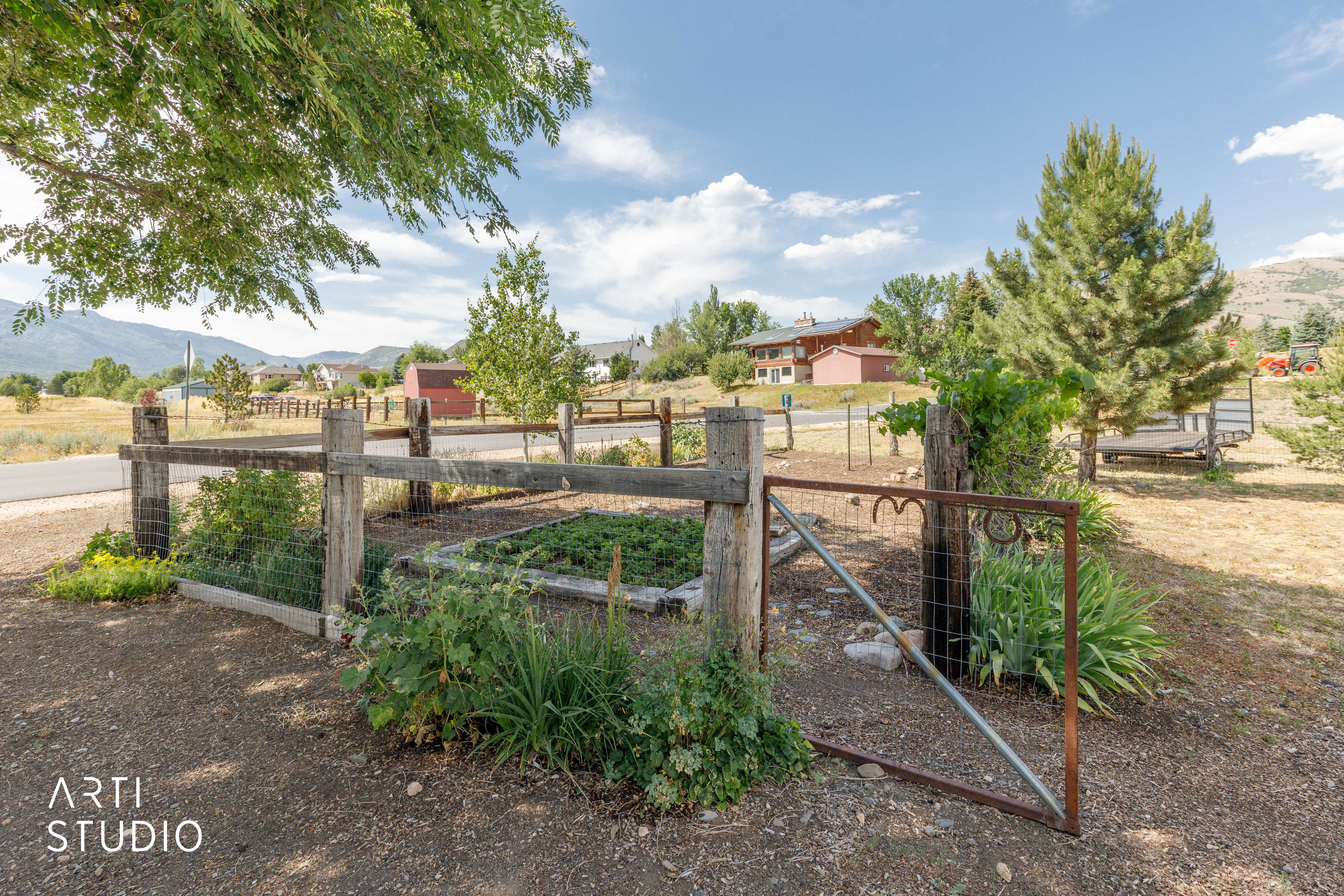 Rustic wood fence with wire mesh, featuring an open metal gate with decorative heart accents