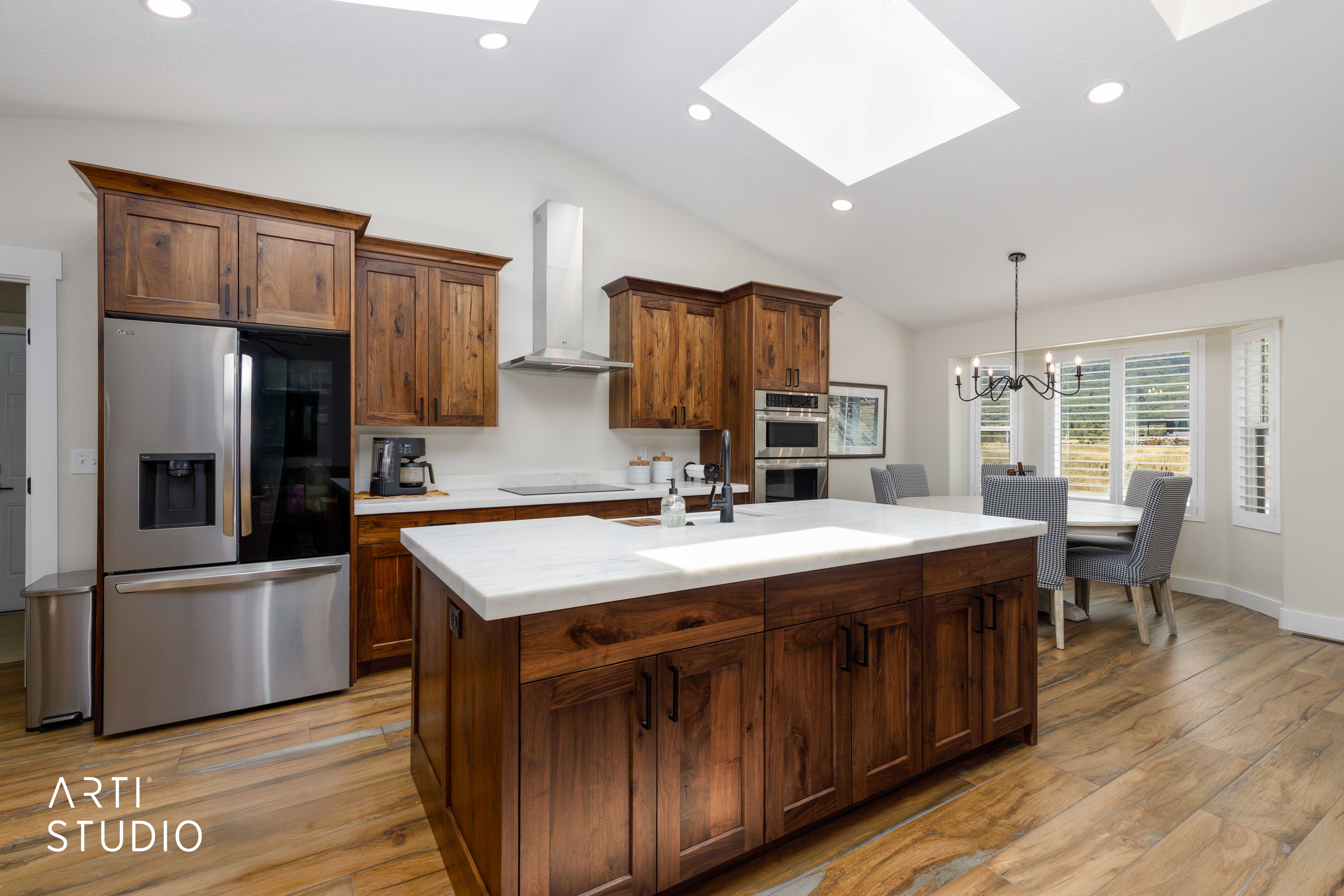 Kitchen featuring a central island with a light-toned countertop, wood-finish flooring, recessed lighting, and skylights