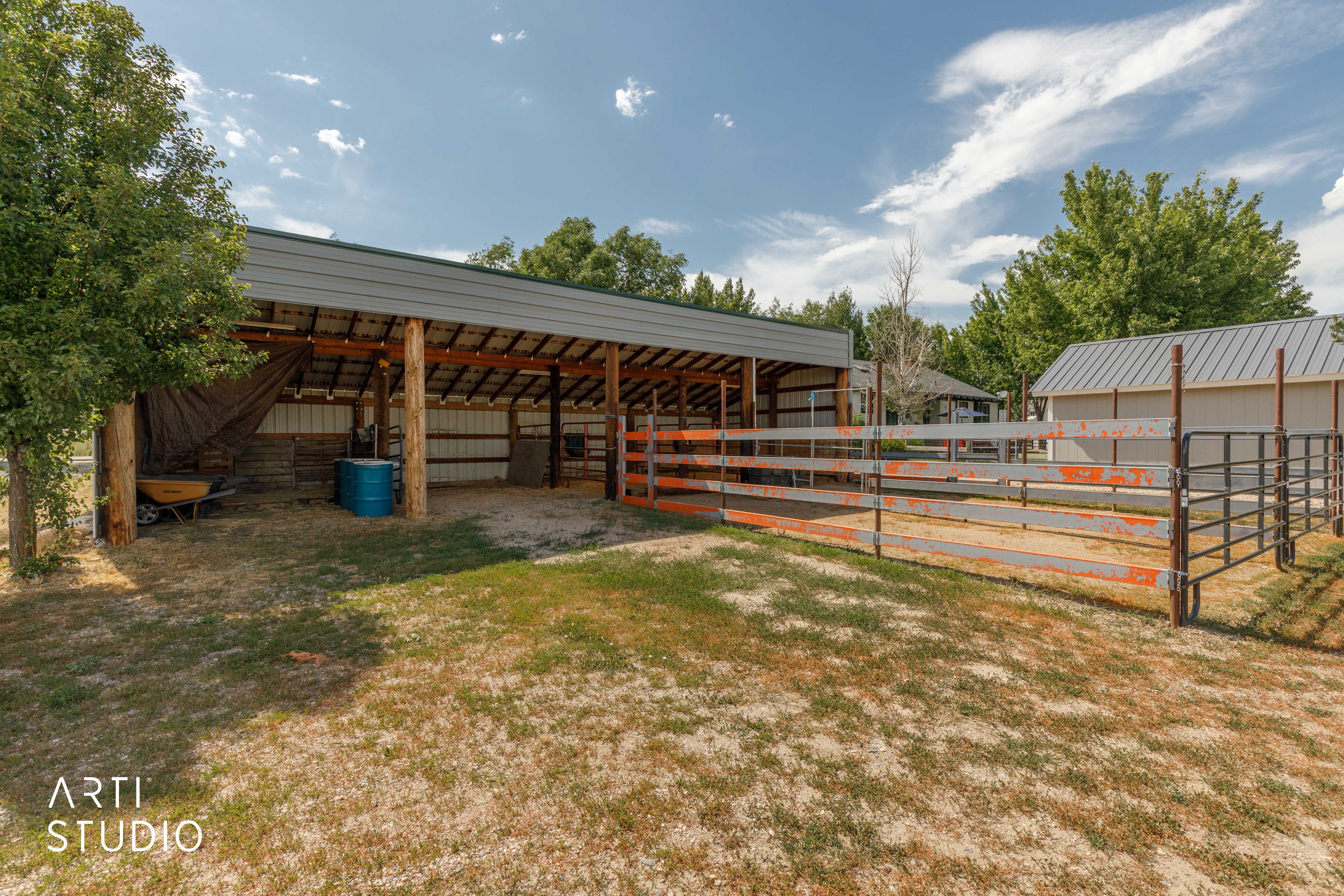 Open-air barn structure with a metal roof and exposed wood beams