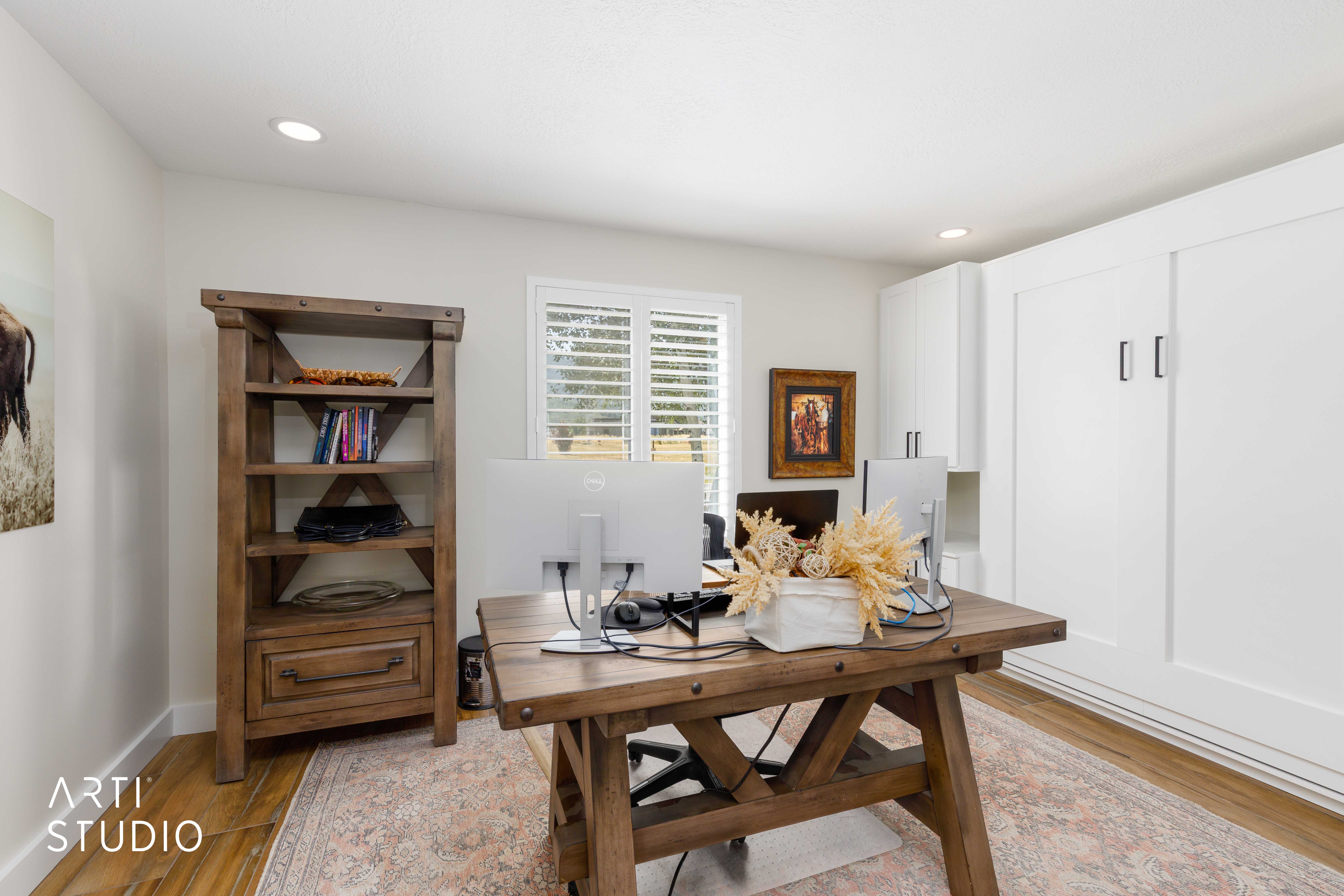 Queen sized Murphy bed. Wood-finish flooring, and a window with plantation shutters