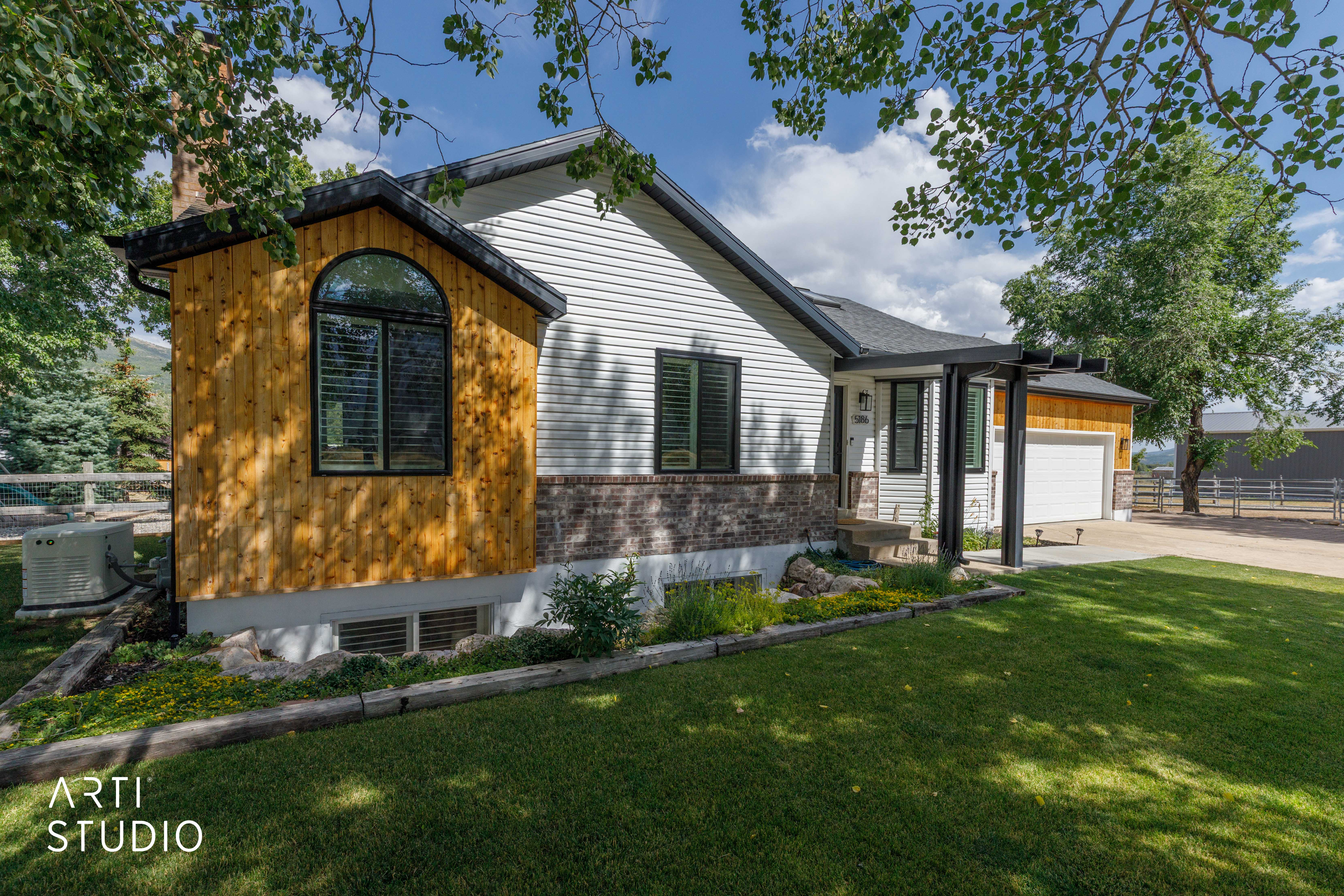 Exterior showcasing natural wood siding, white horizontal siding, and a partial brick facade