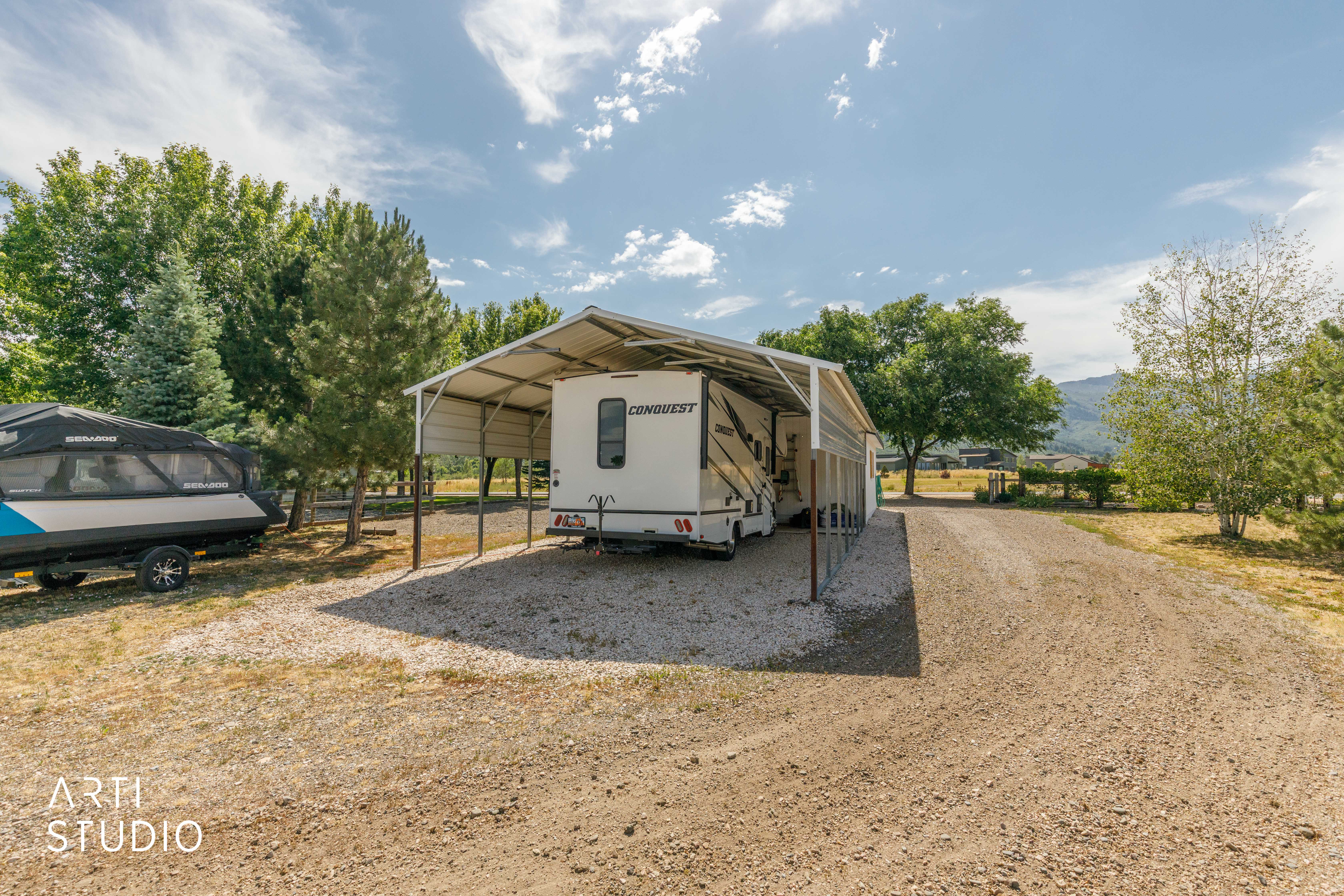 Gravel drive with a metal carport providing covered parking