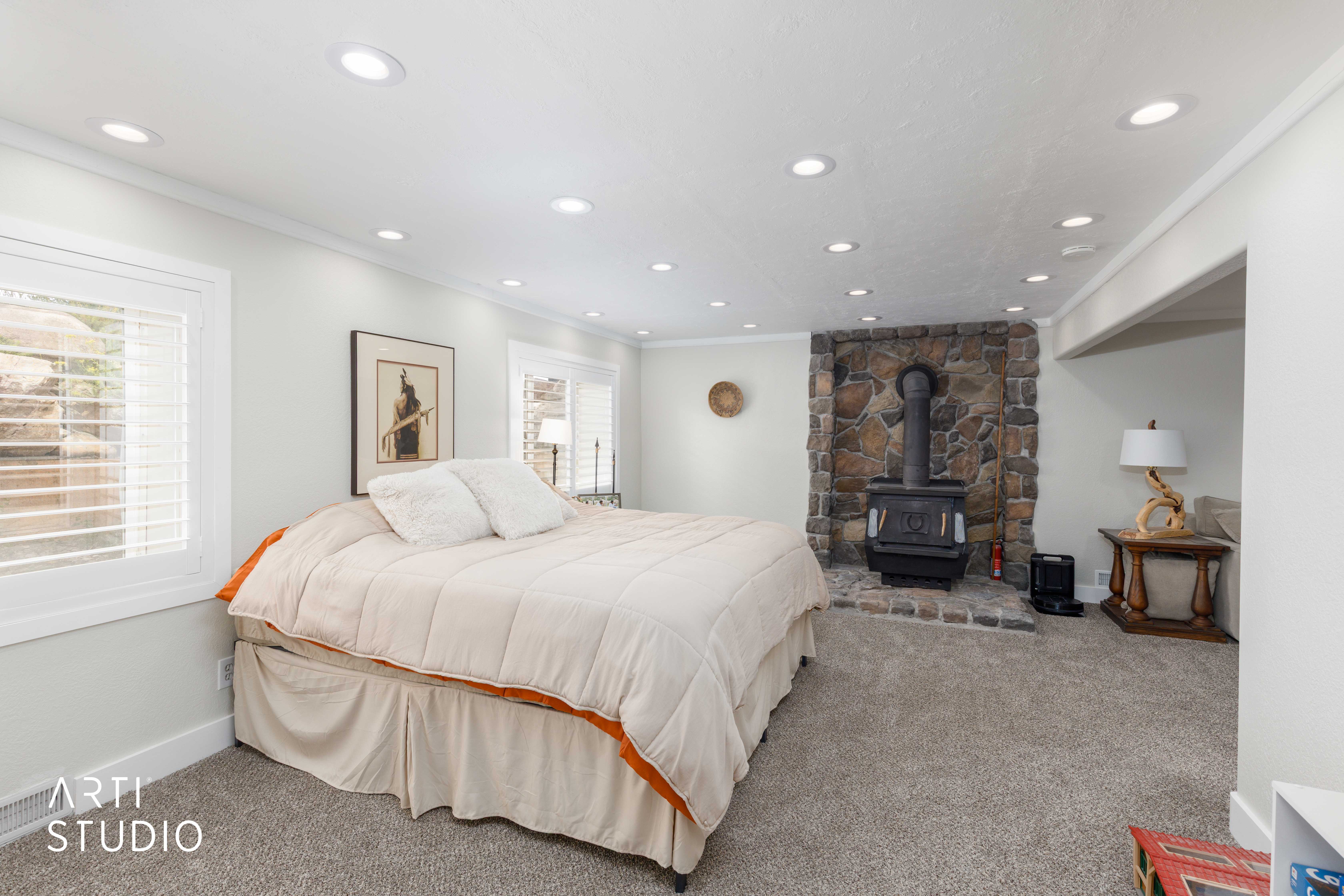 Interior space featuring recessed lighting, a stone accent wall, and a freestanding stove with a stone hearth