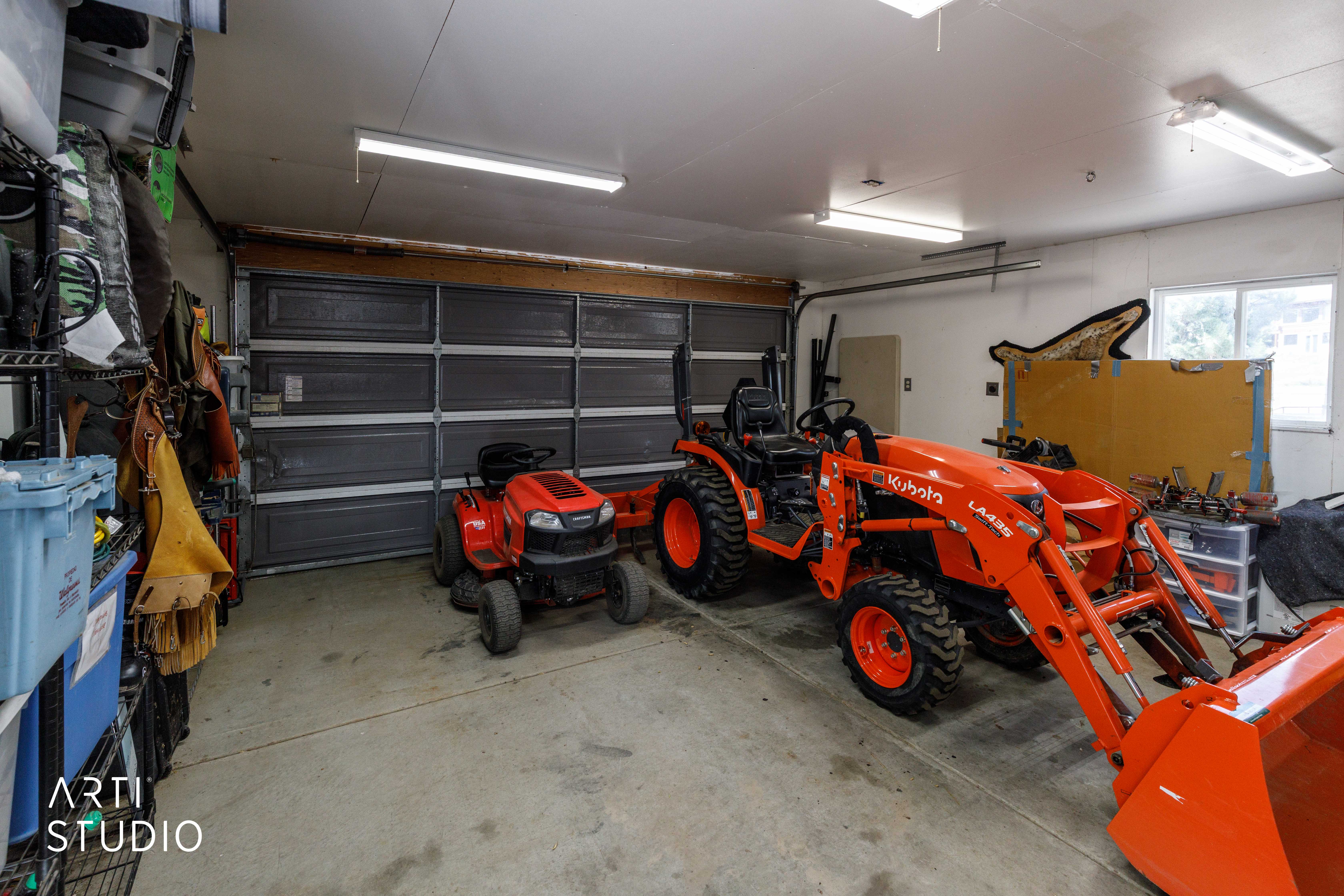 Garage with concrete flooring, fluorescent lighting, and a window providing natural light