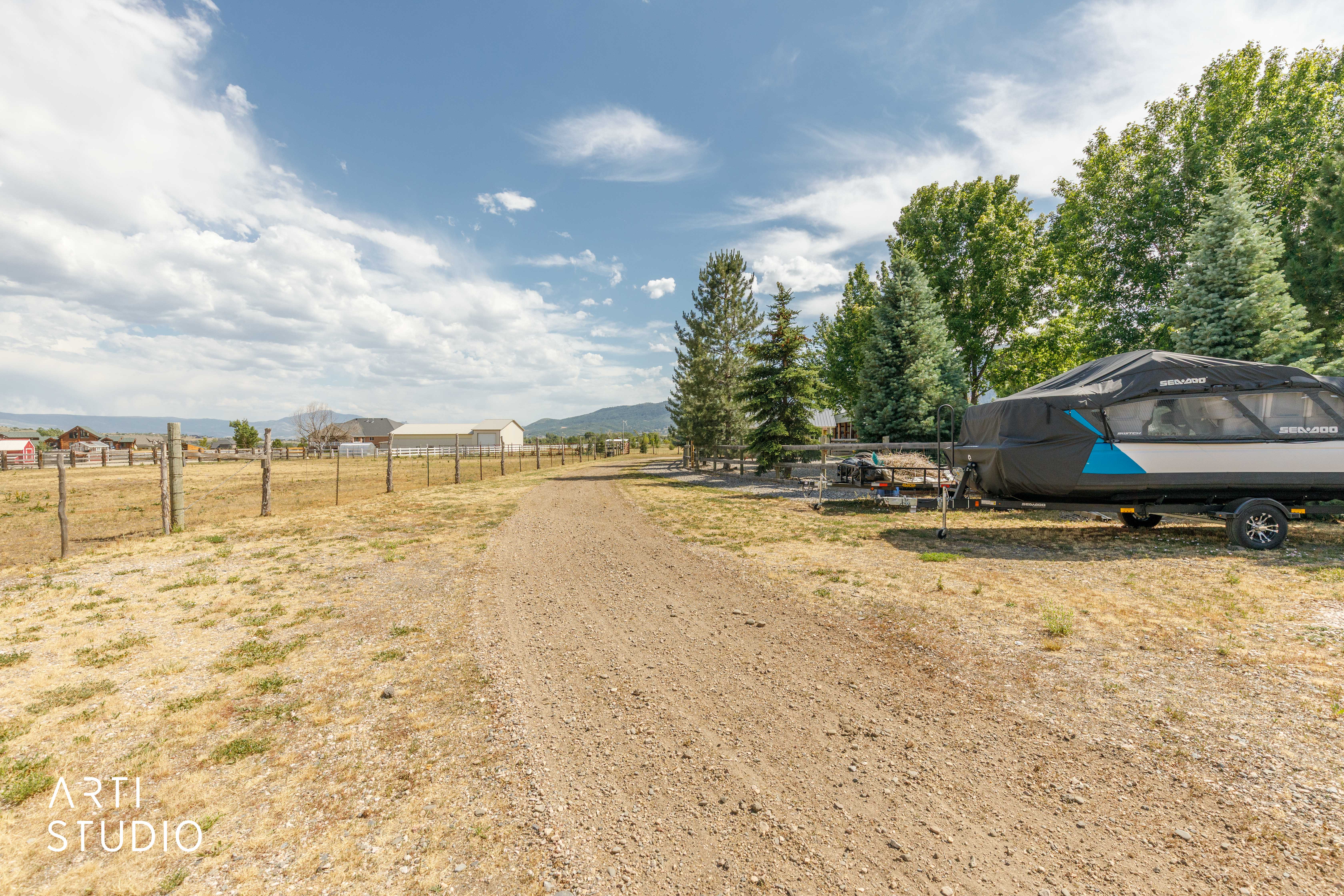Extensive gravel driveway with a treed perimeter