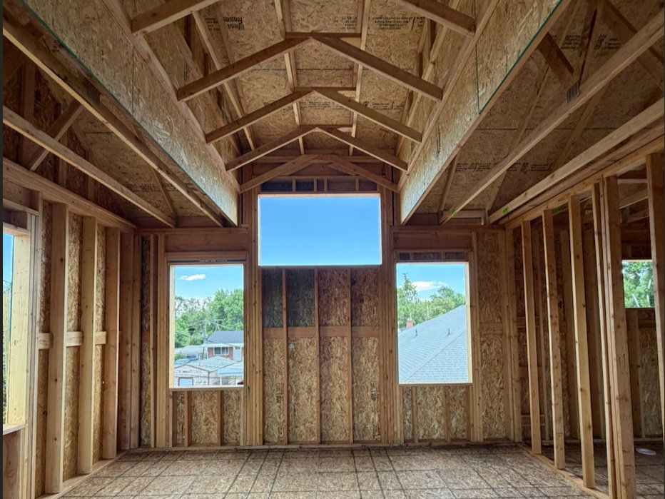 Primary bedroom with vaulted ceilings and large windows.