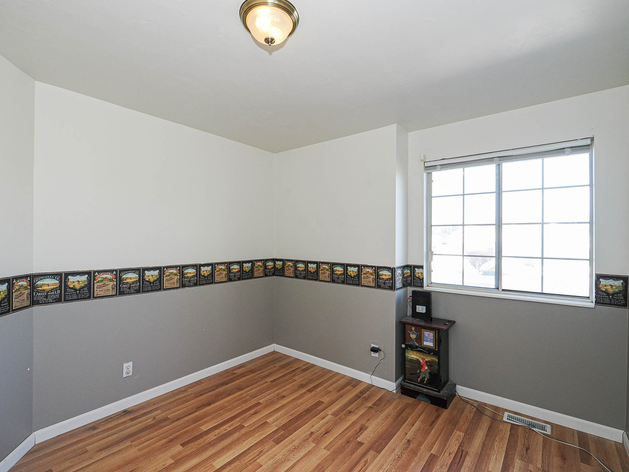 Room featuring wood-finish flooring, a double-pane window, and a flush mount ceiling light fixture