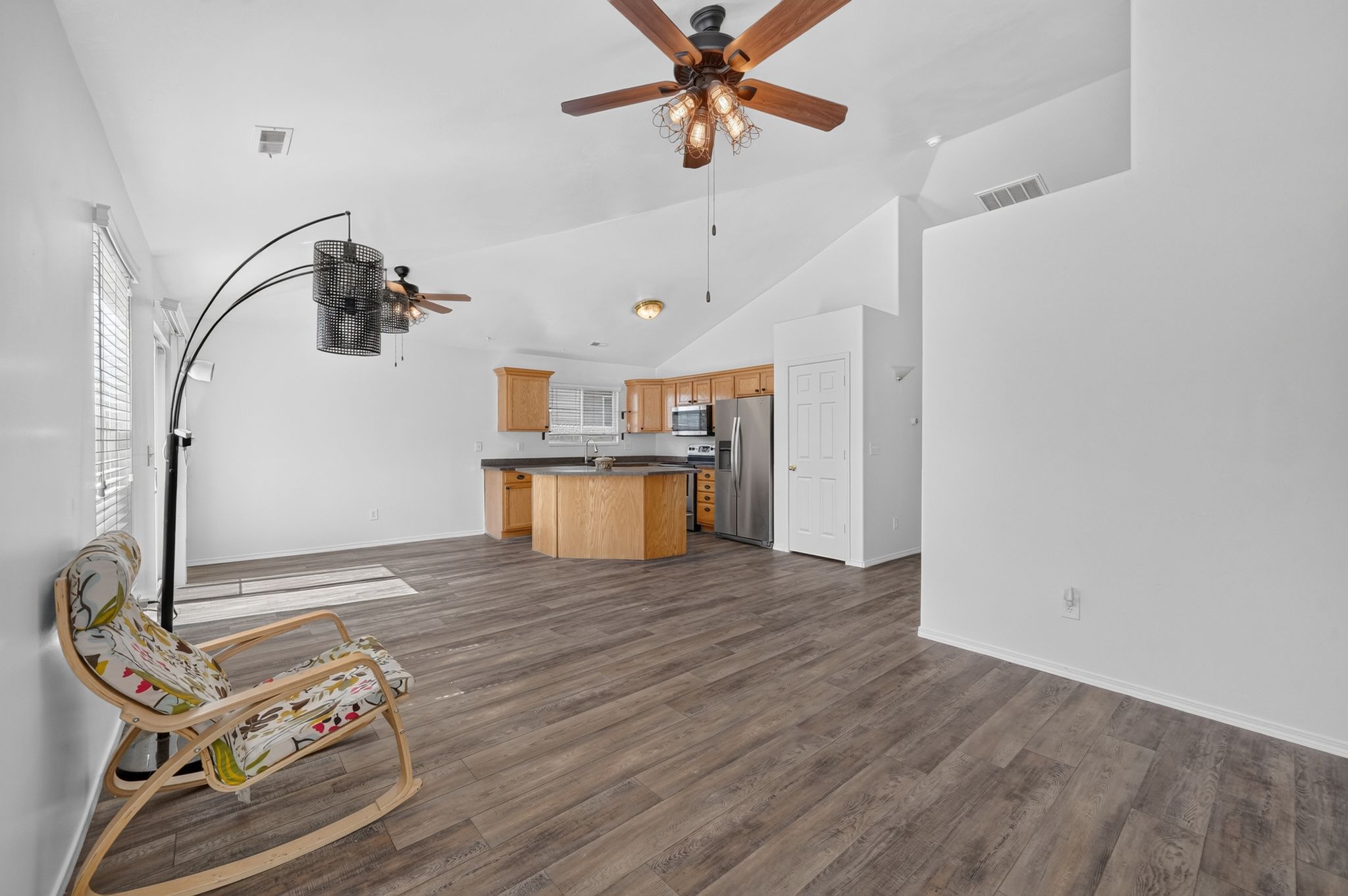 Vaulted ceilings above wood-finish flooring in an open-concept living area