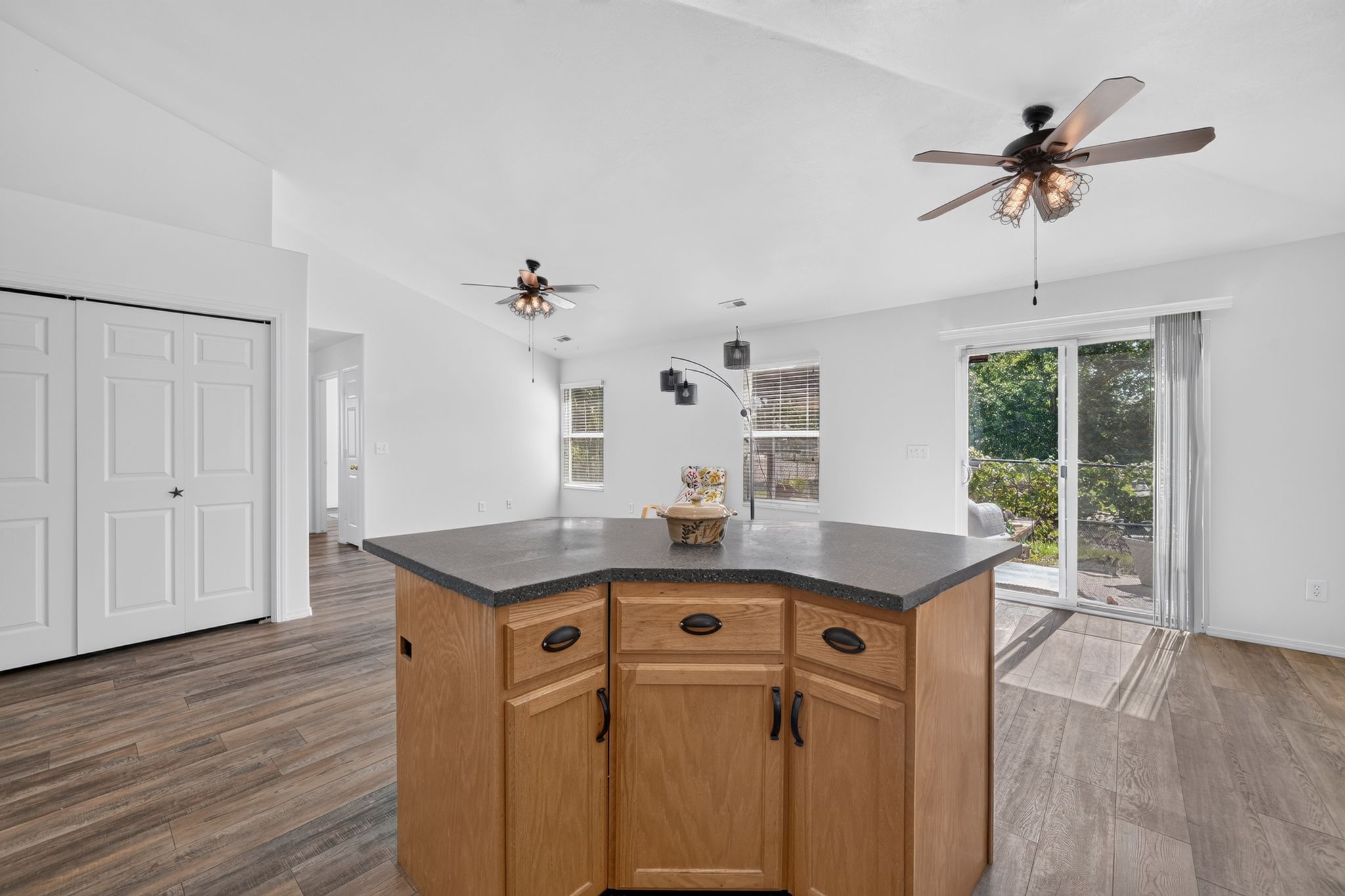 Central kitchen island featuring wood-finish cabinetry and a dark countertop