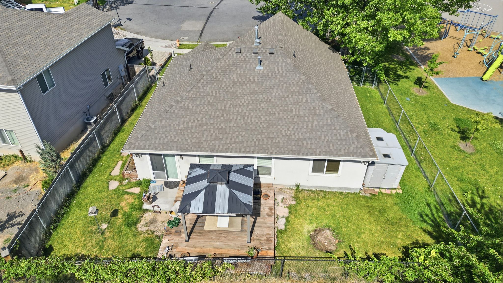 Backyard featuring a wood deck with a gazebo, a concrete patio area, and a storage shed