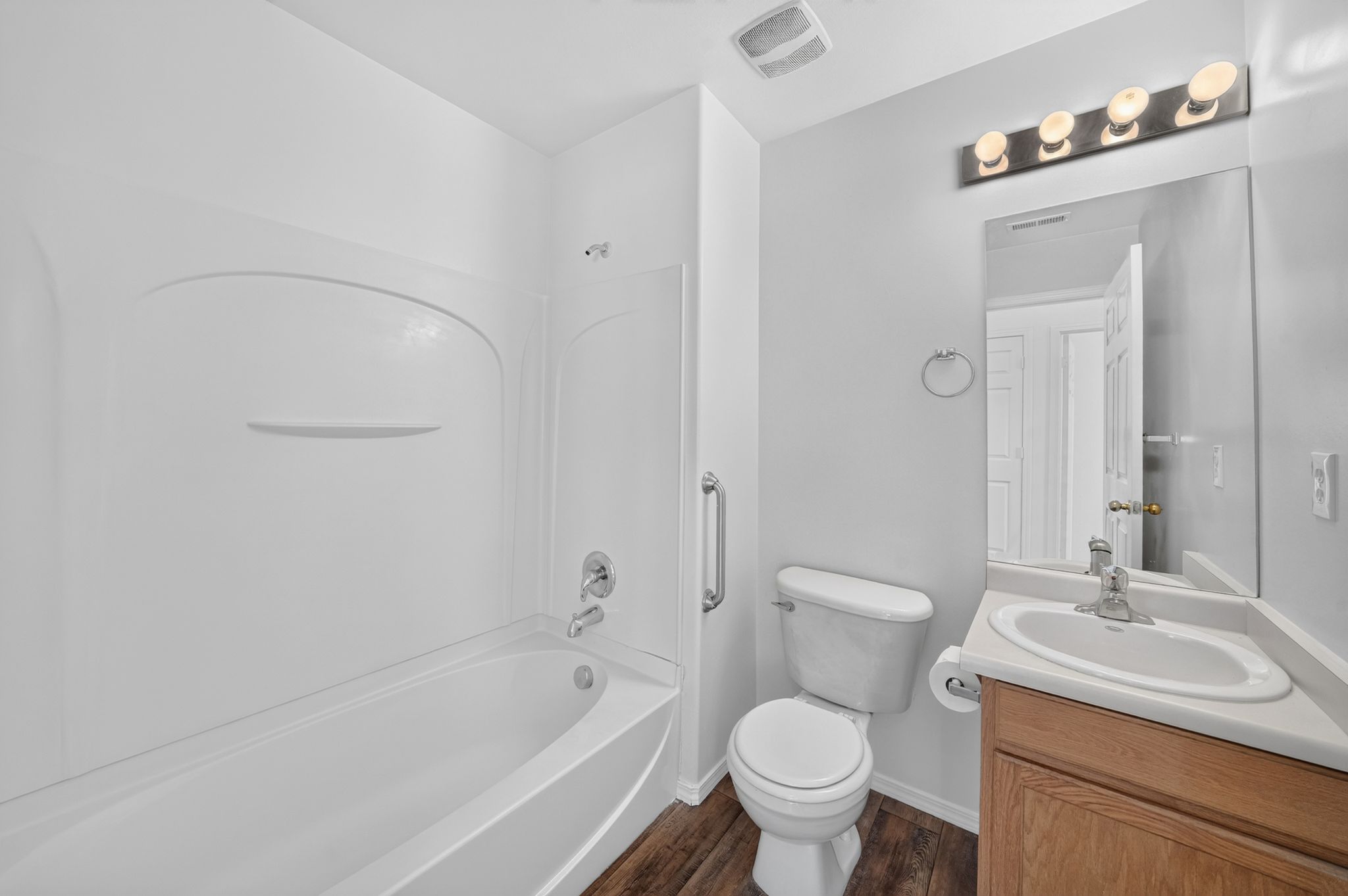 White bathtub and shower surround with chrome fixtures
