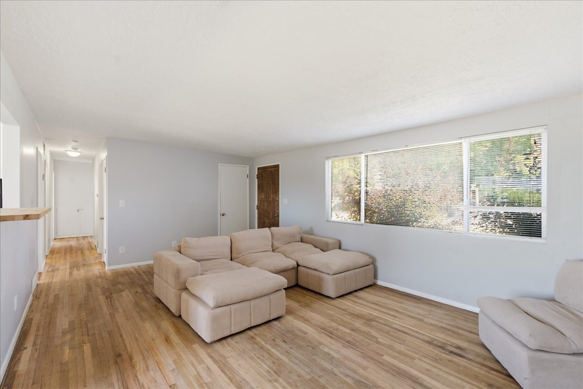 Spacious living area featuring wood-finish flooring, light gray walls, and white trim