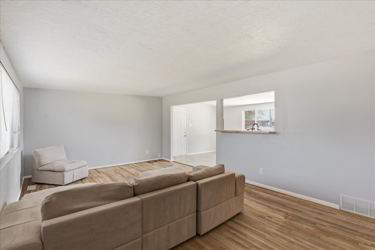 Spacious living area featuring wood-finish flooring, light gray walls, and white trim