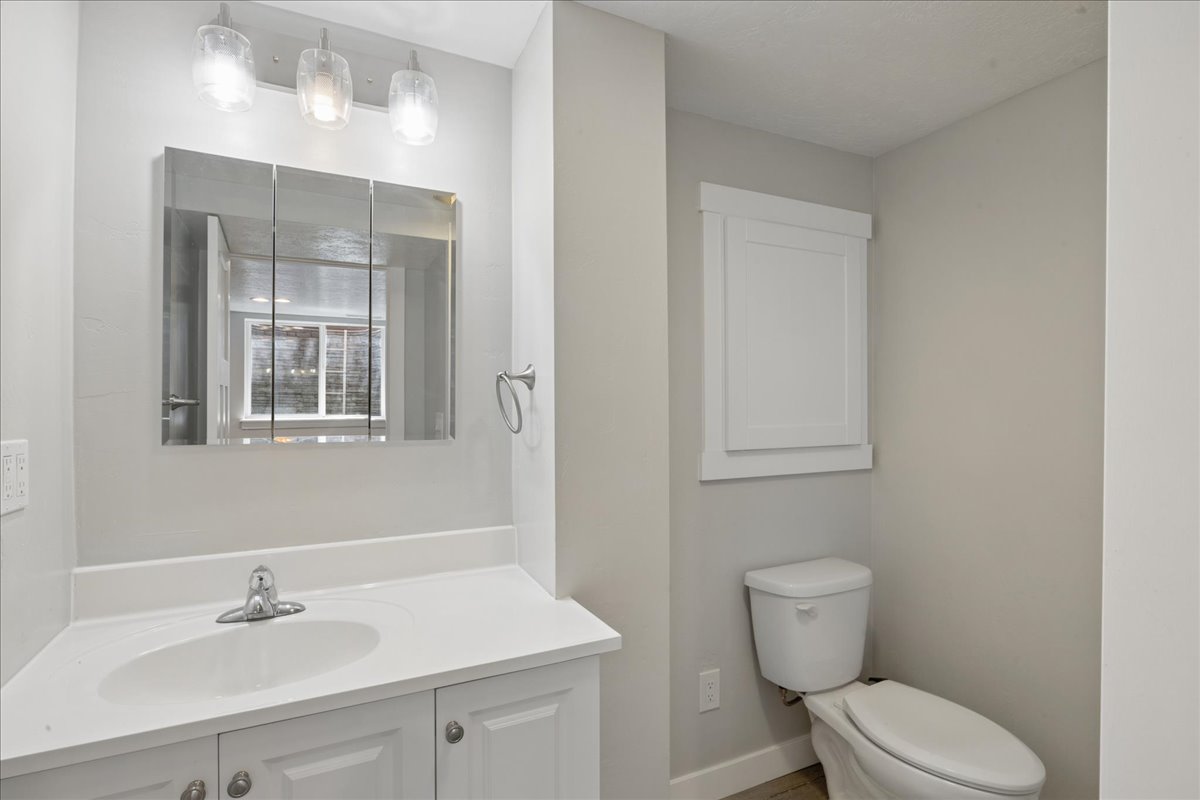 Bathroom featuring a vanity with white cabinetry, a white countertop, and an undermount sink