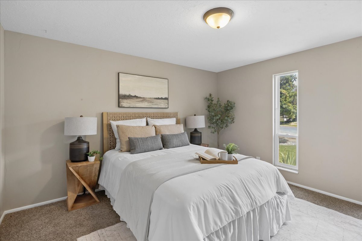 Carpeted bedroom featuring neutral wall tones and a single vertical window